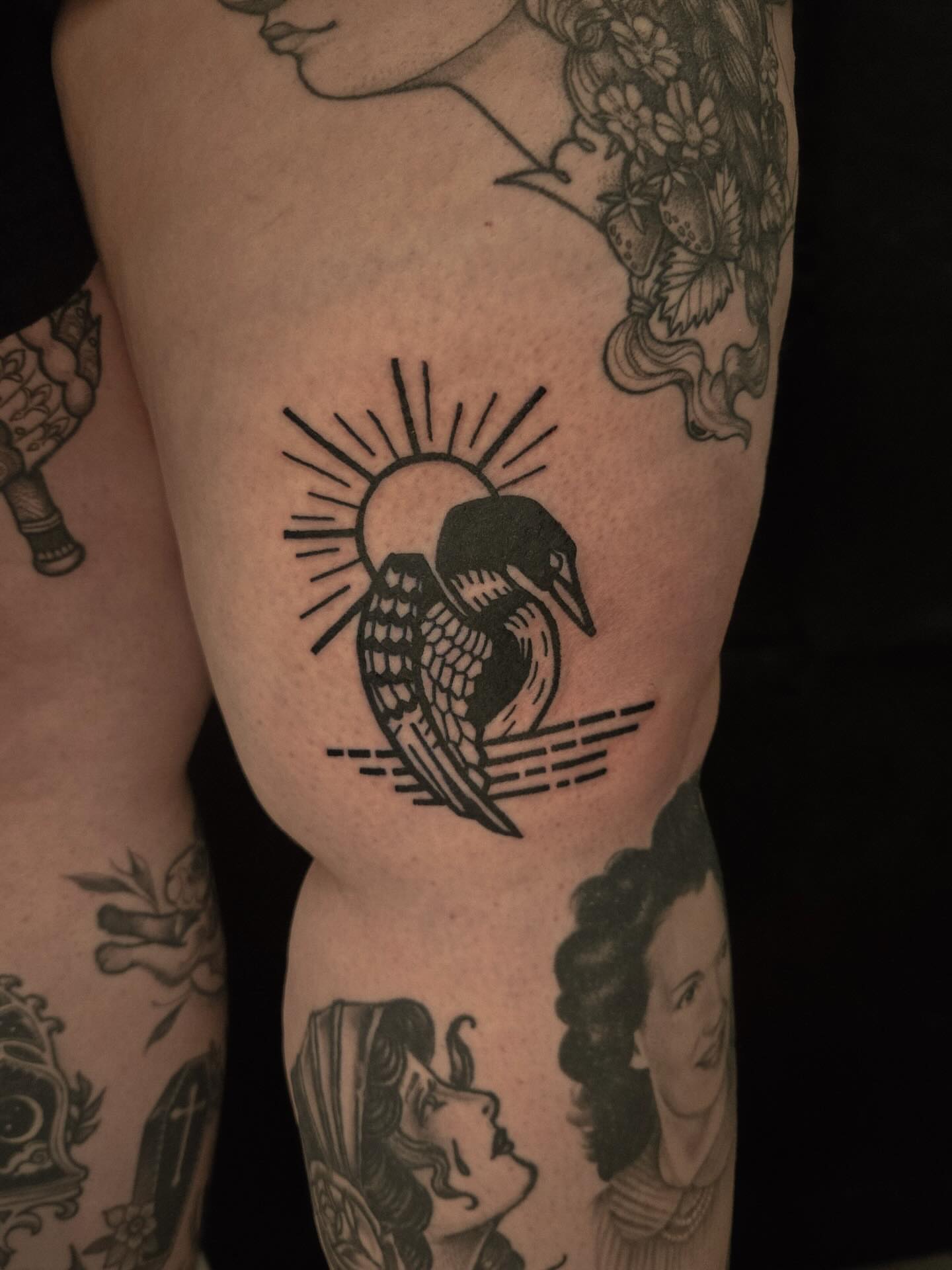 Loon and sun black and grey tattoo on the thigh by ashley blyght