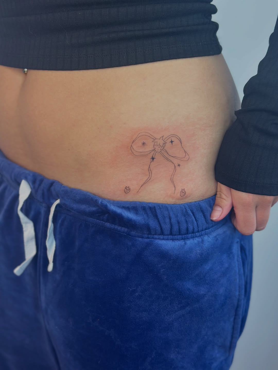 Bow with stars minimalist tattoo on the torso by Cherry🥀