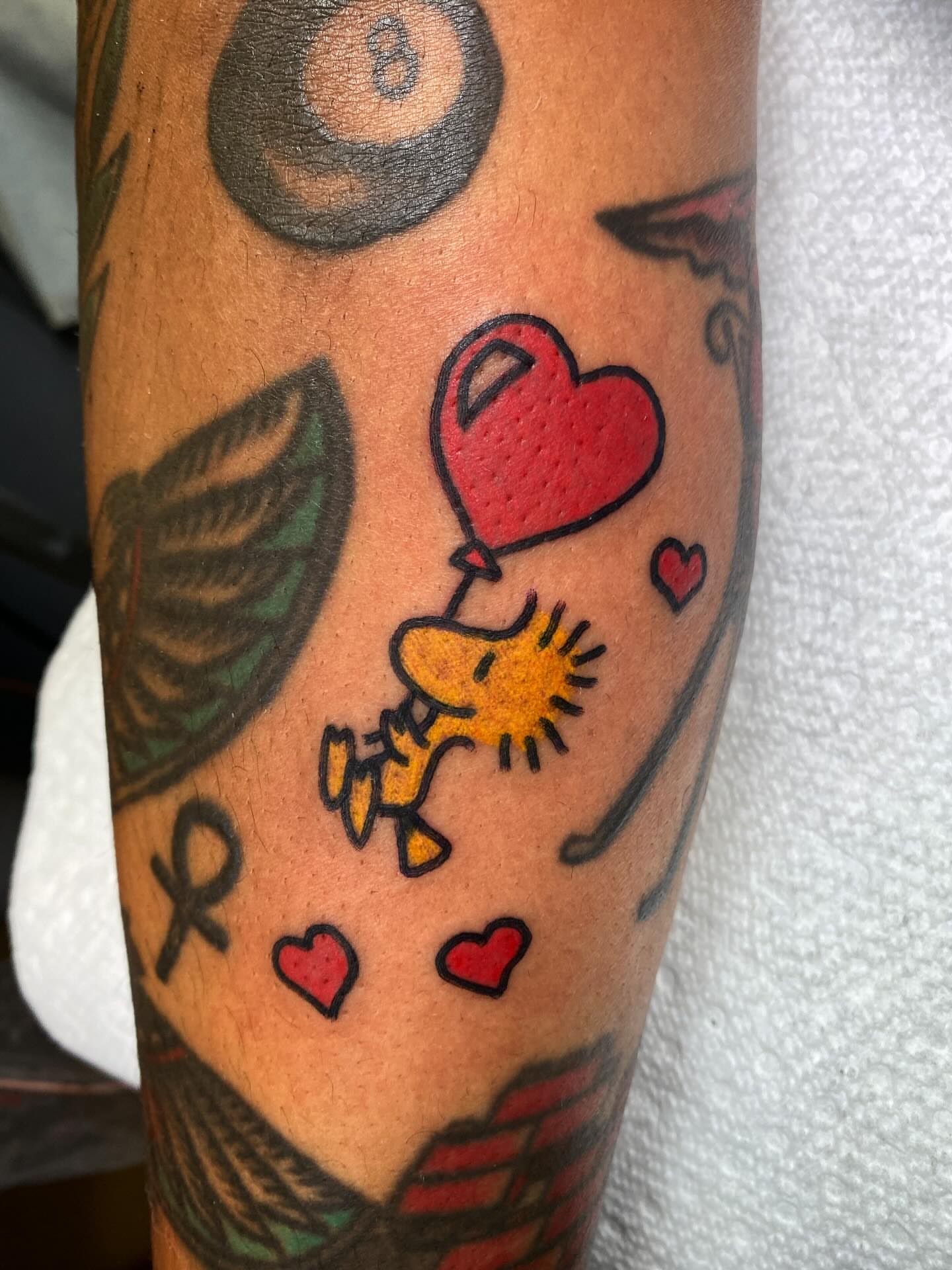 Woodstock with heart balloon American traditional tattoo on the forearm by @rubber_band_dan, San Francisco, California