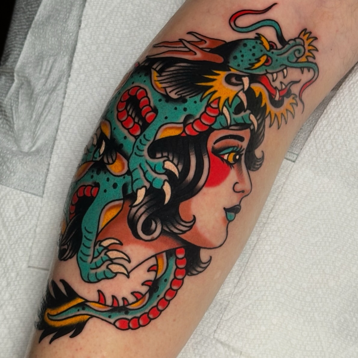 Woman with dragon American traditional tattoo on the forearm by Schyler Ames, Canal Fulton, Ohio