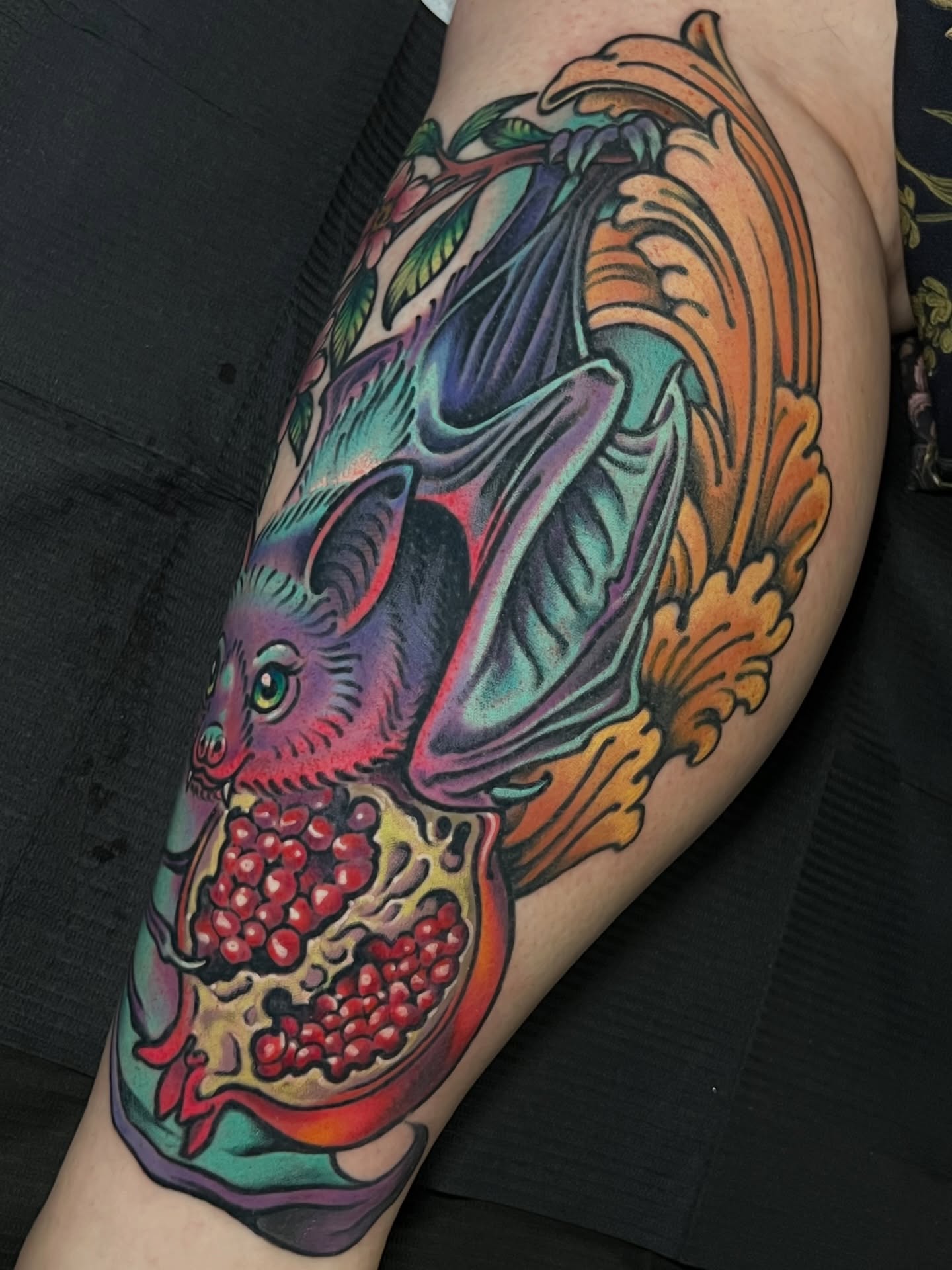 Bat and pomegranate American traditional tattoo on the thigh by Fredd Chino