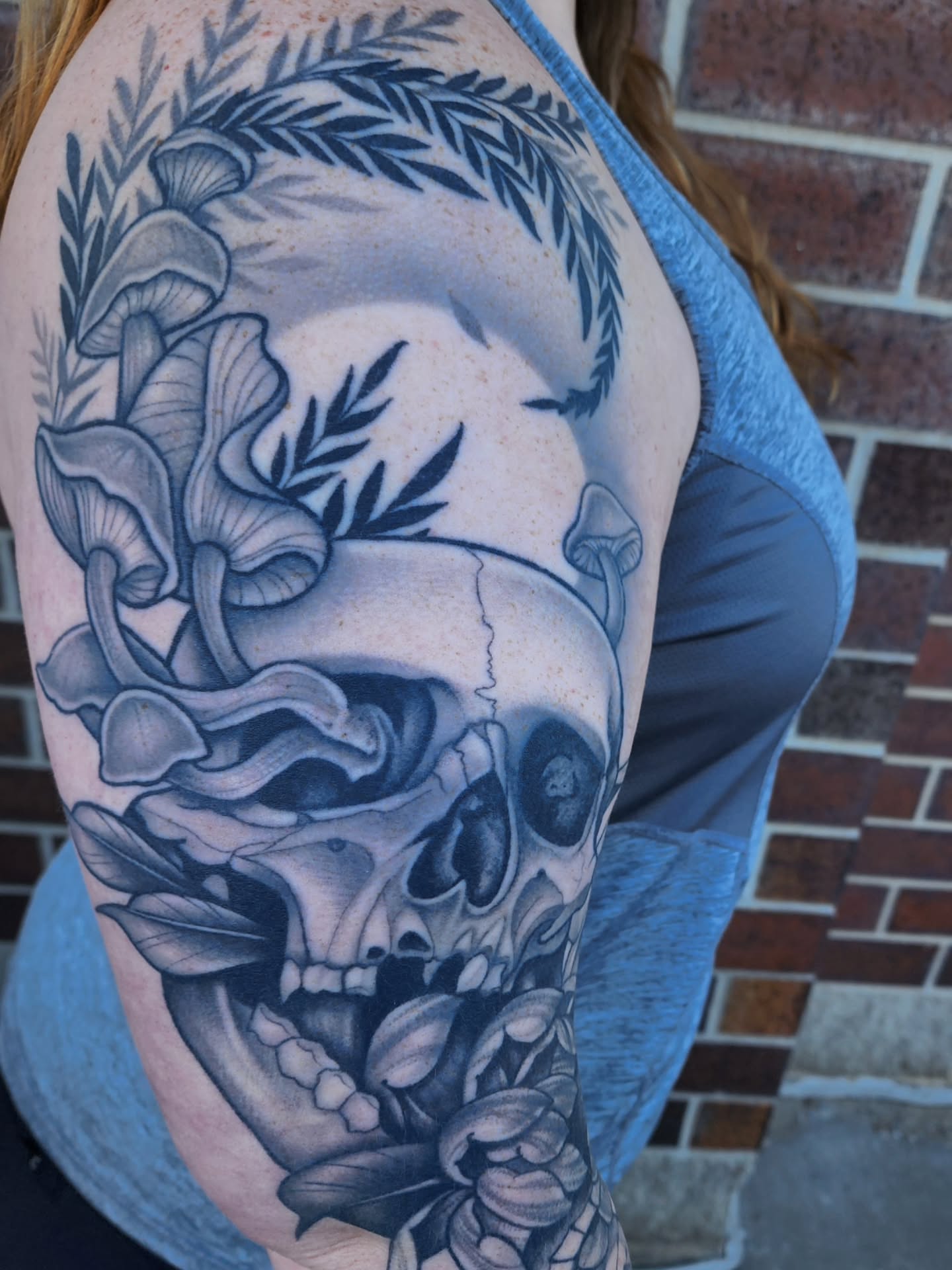 Skull with flowers realism tattoo on the forearm by Shawna Goettsche