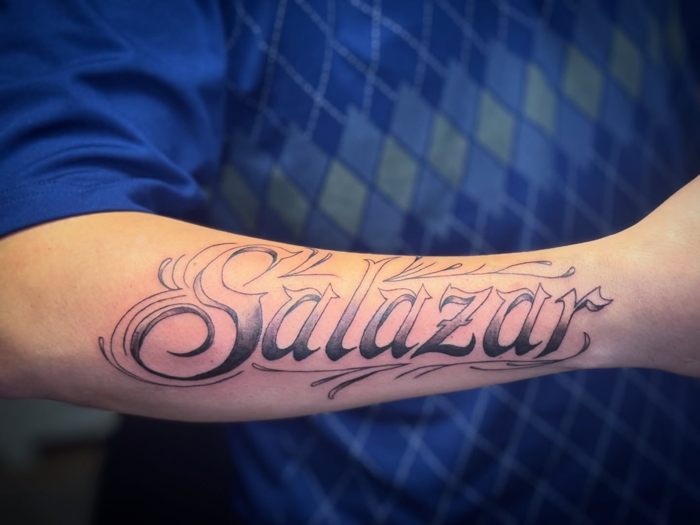 Salazar lettering script tattoo on the forearm by Kate