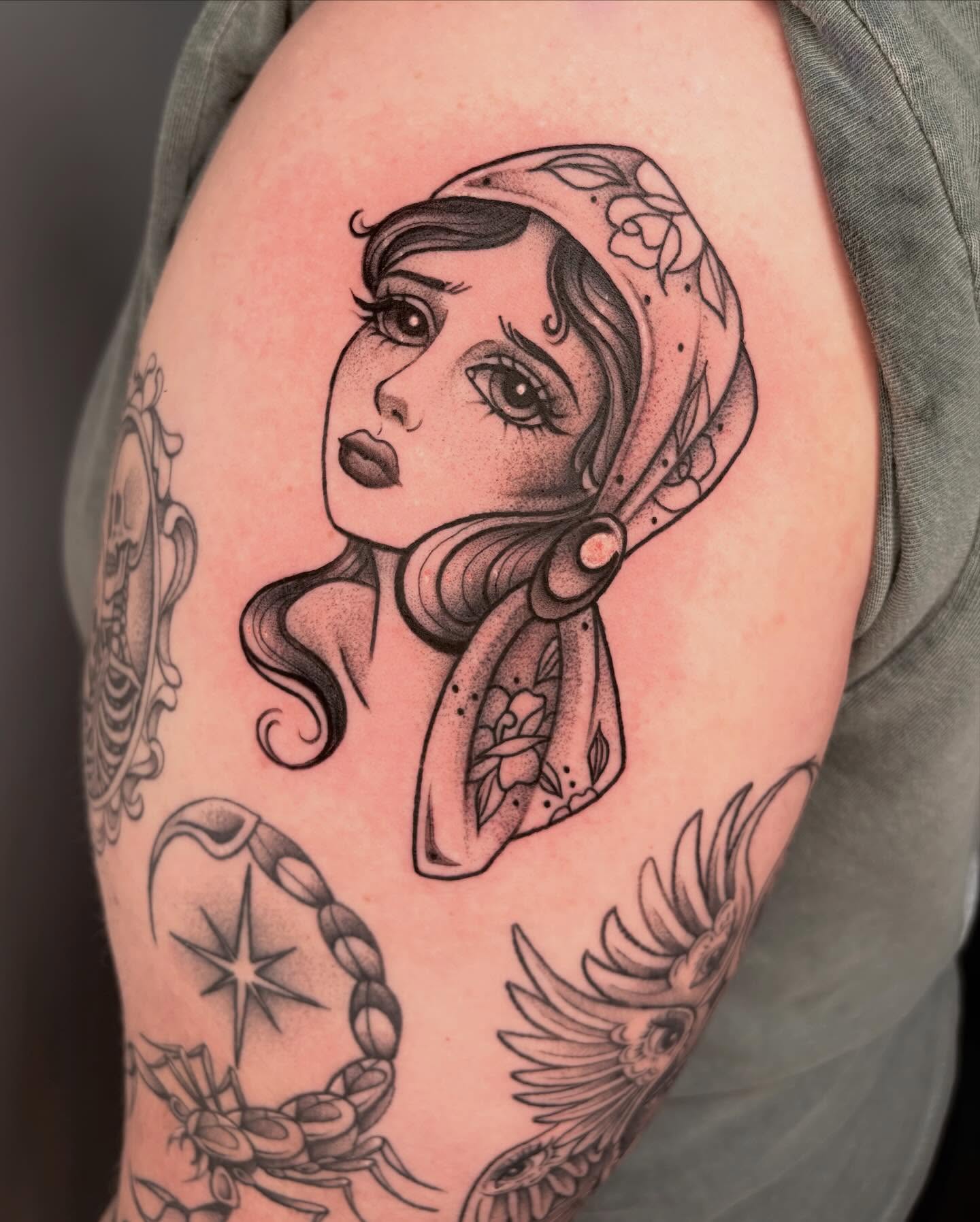 Woman with scarf dotwork tattoo on the shoulder by Avery Mullins