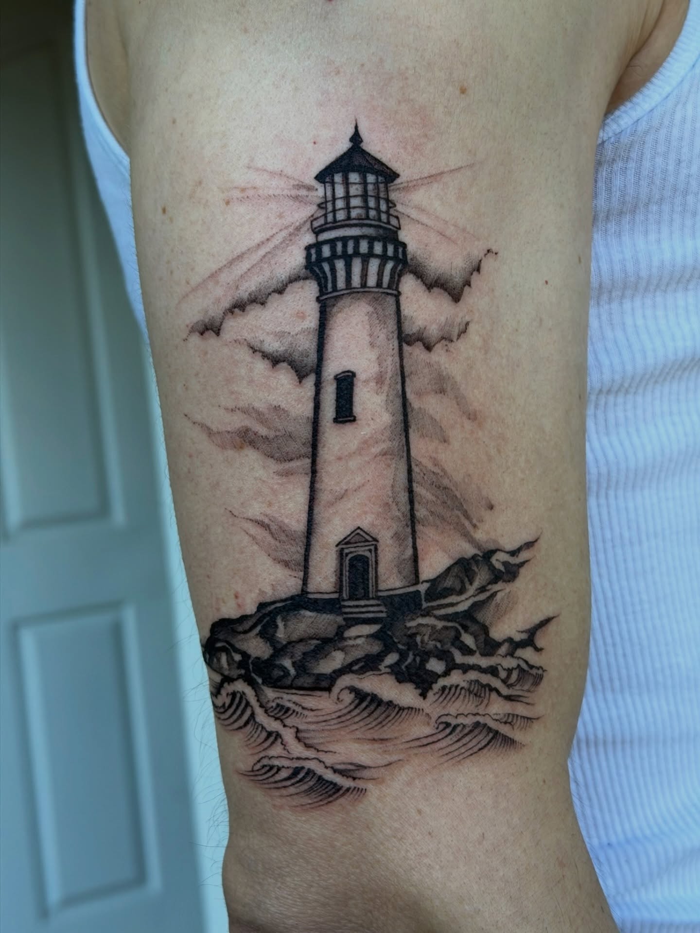 Lighthouse realism tattoo on the forearm by Kingtide Ink