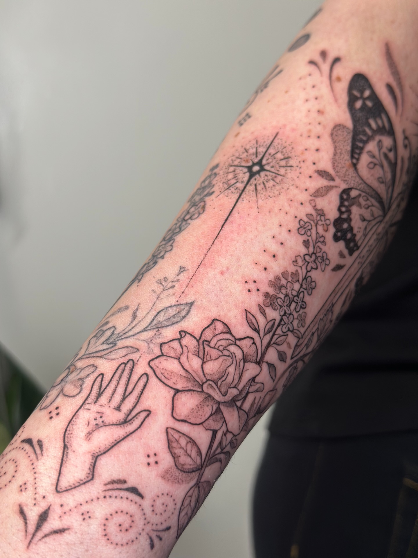 Floral and hand design dotwork tattoo on the forearm by Santiago Don, Portland, Oregon