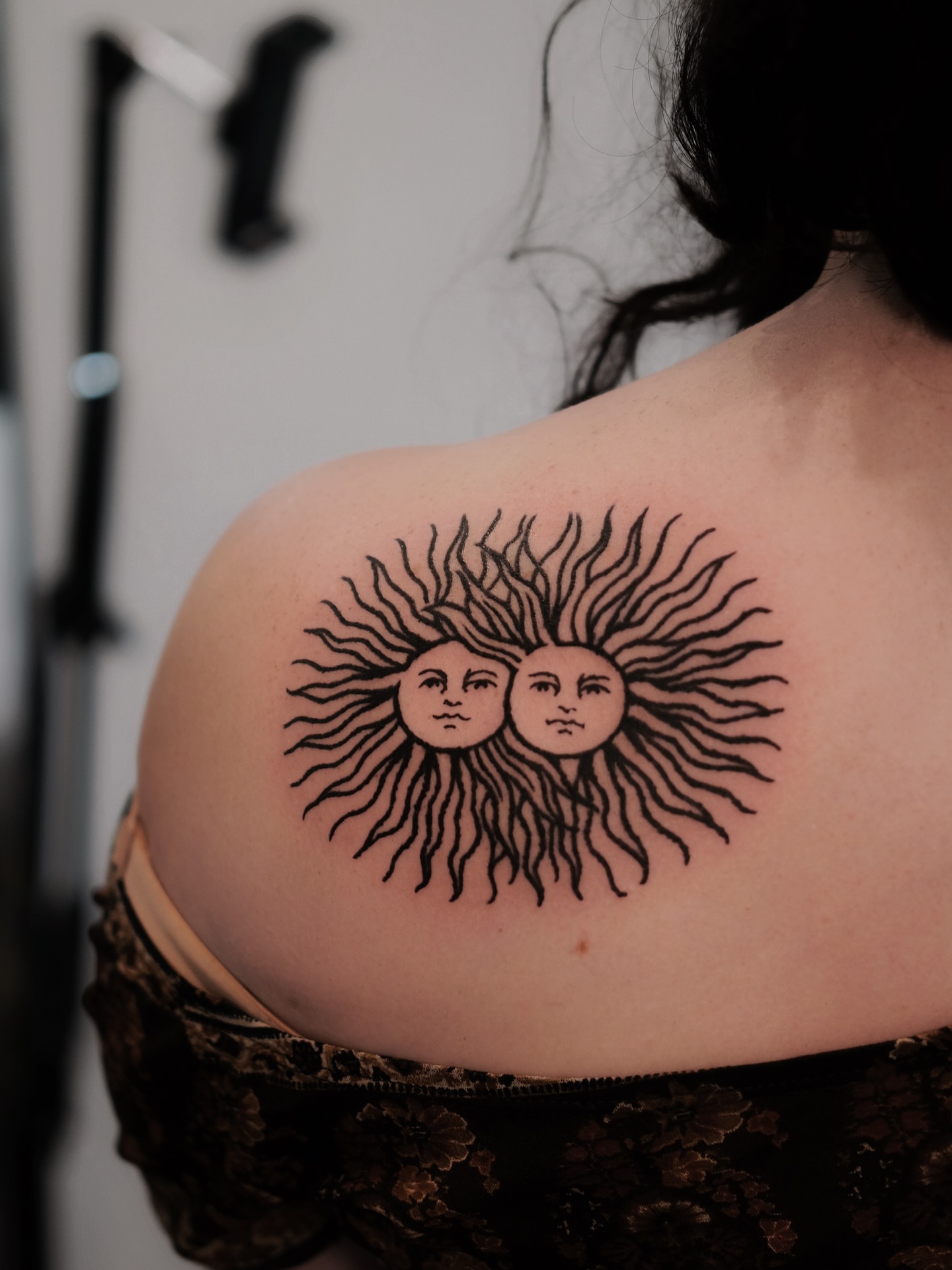 Sun faces black and grey tattoo on the shoulder by ꜰʟᴏʀᴀ ᴡᴏᴏᴅᴄᴜᴛ ᴛᴀᴛᴛᴏᴏ