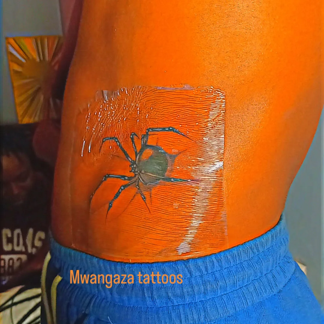 Spider American traditional tattoo on the thigh by Mwangaza Bodyworks, Uthiru, Nairobi Area, Kenya