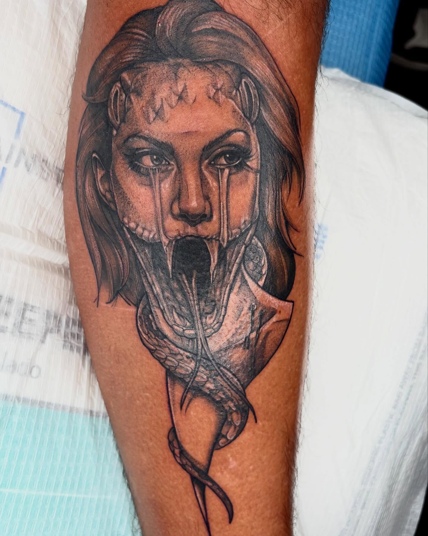 Woman with snake realism tattoo on the forearm by Emily Falkowski