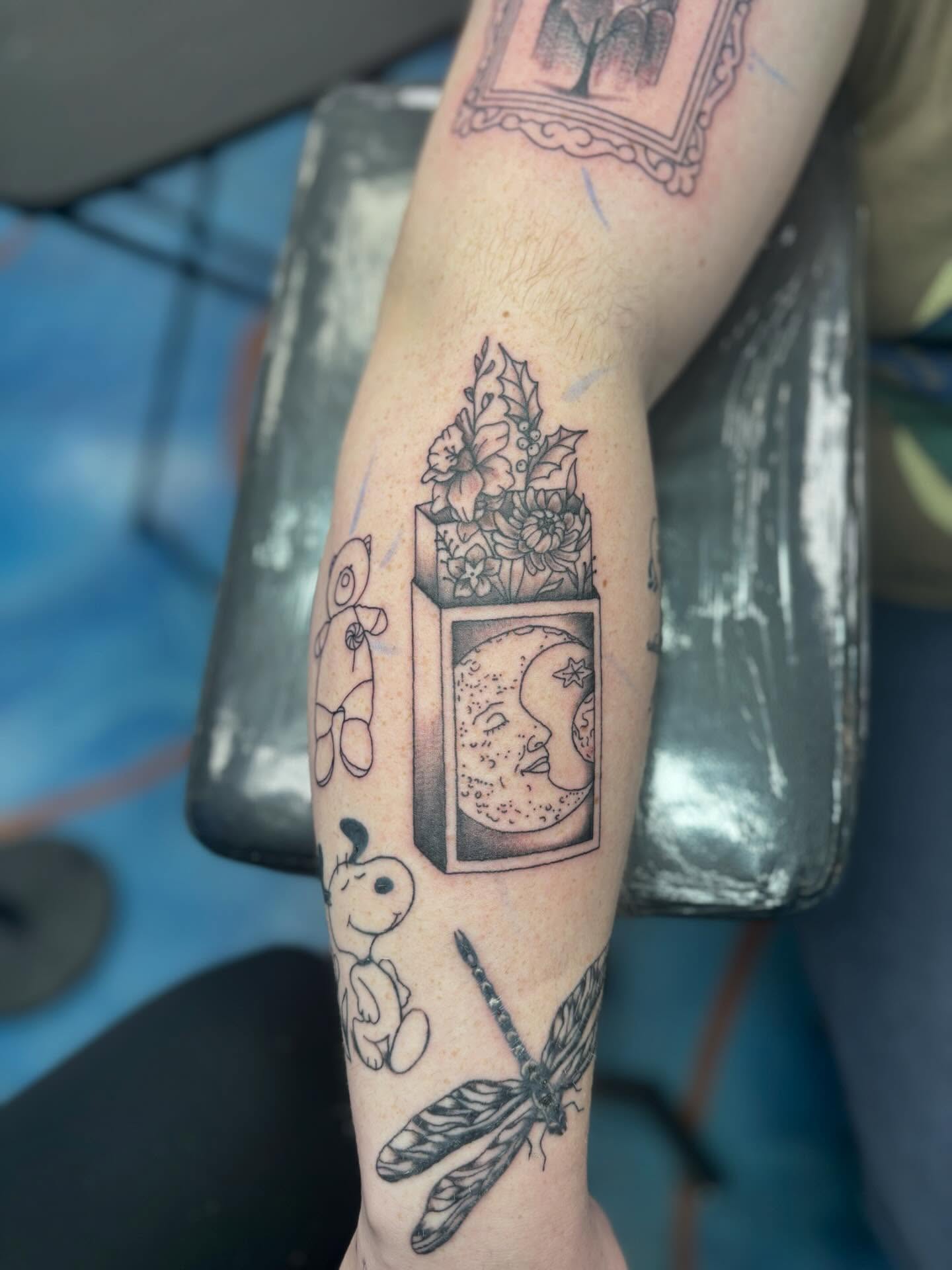 Moon and flowers black and grey tattoo on the forearm by Cam Sykes