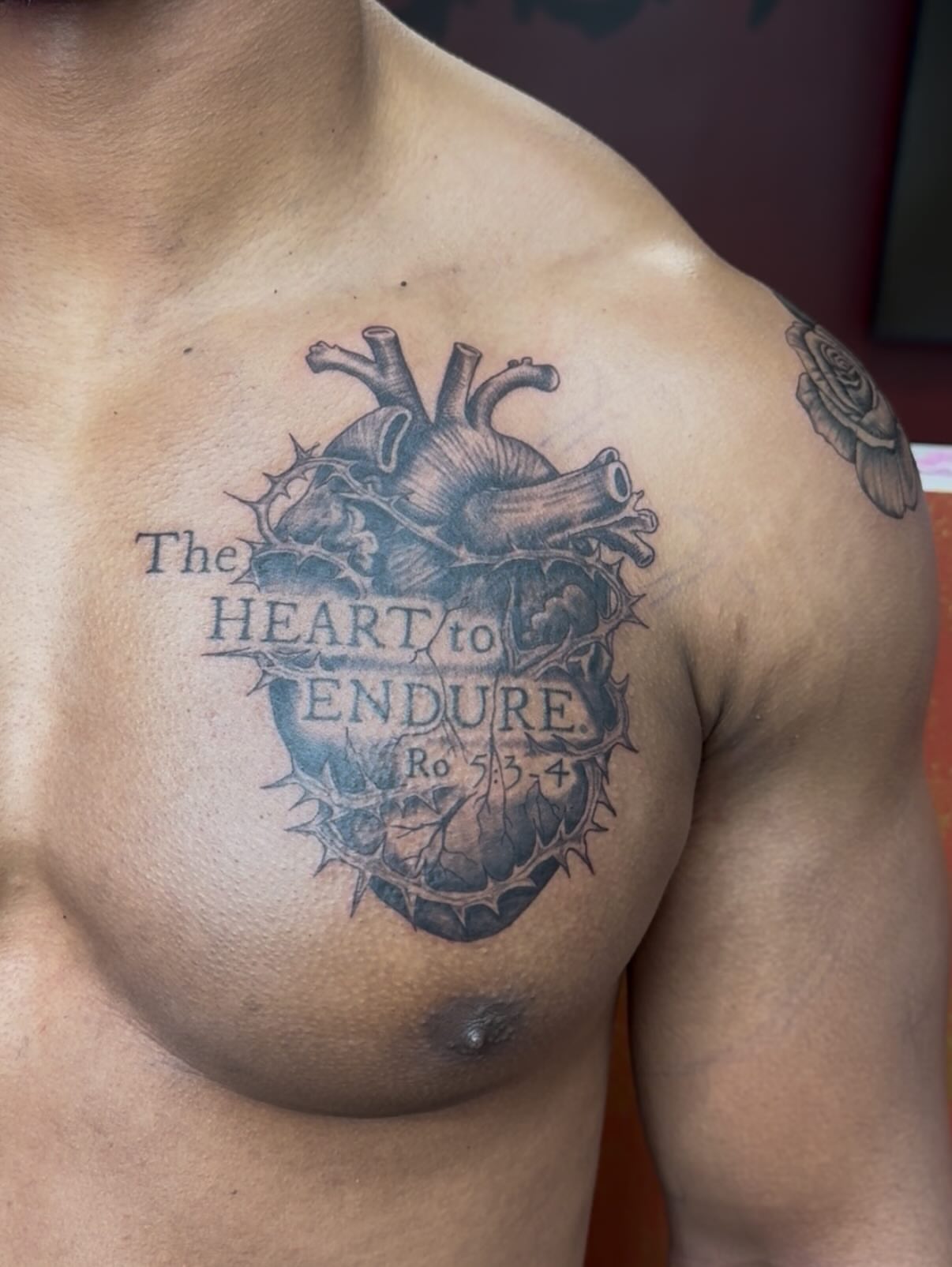 Heart with thorns black and grey tattoo on the chest by Imani