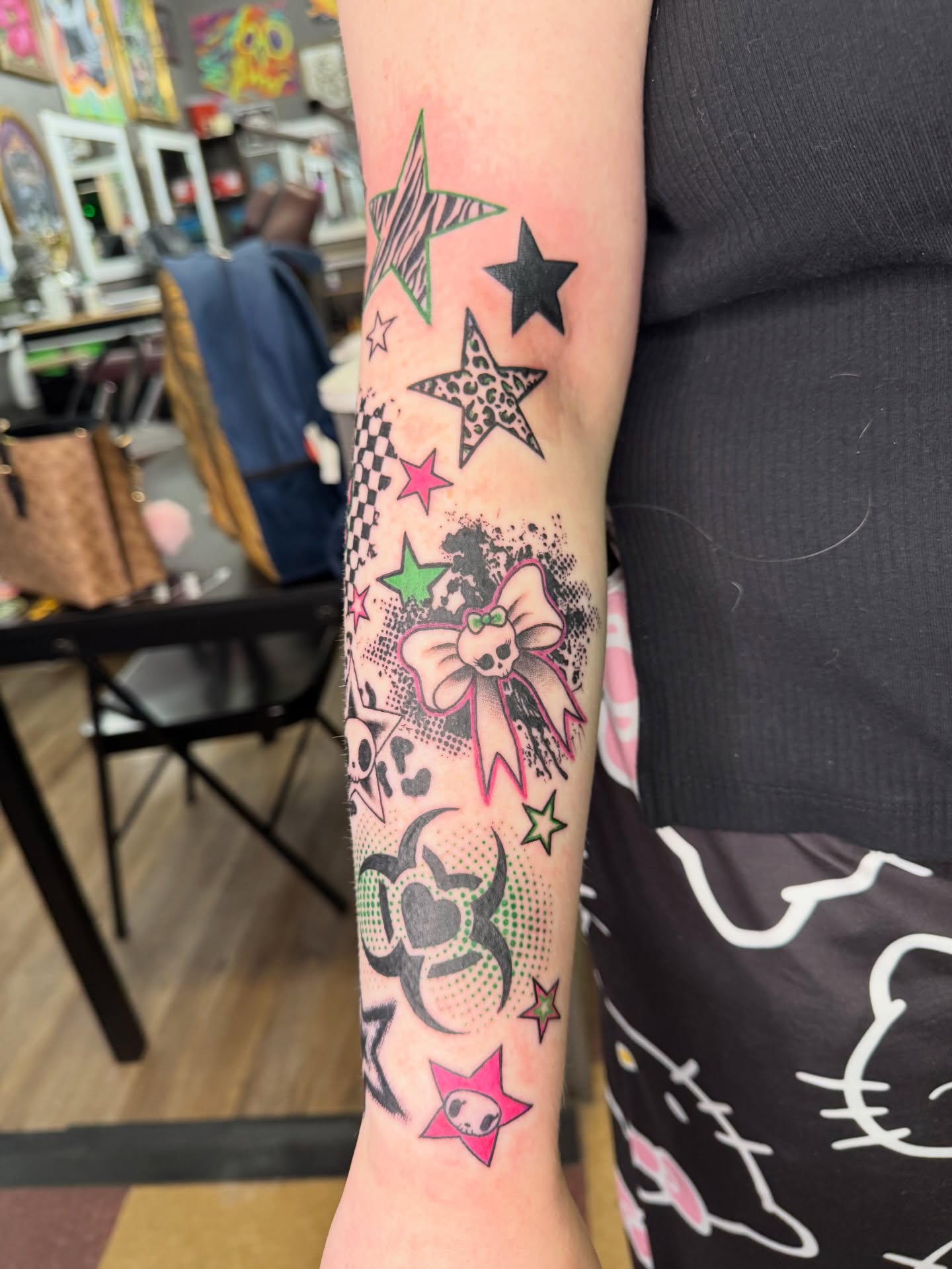 Stars and bow dotwork tattoo on the forearm by Cora Phelps