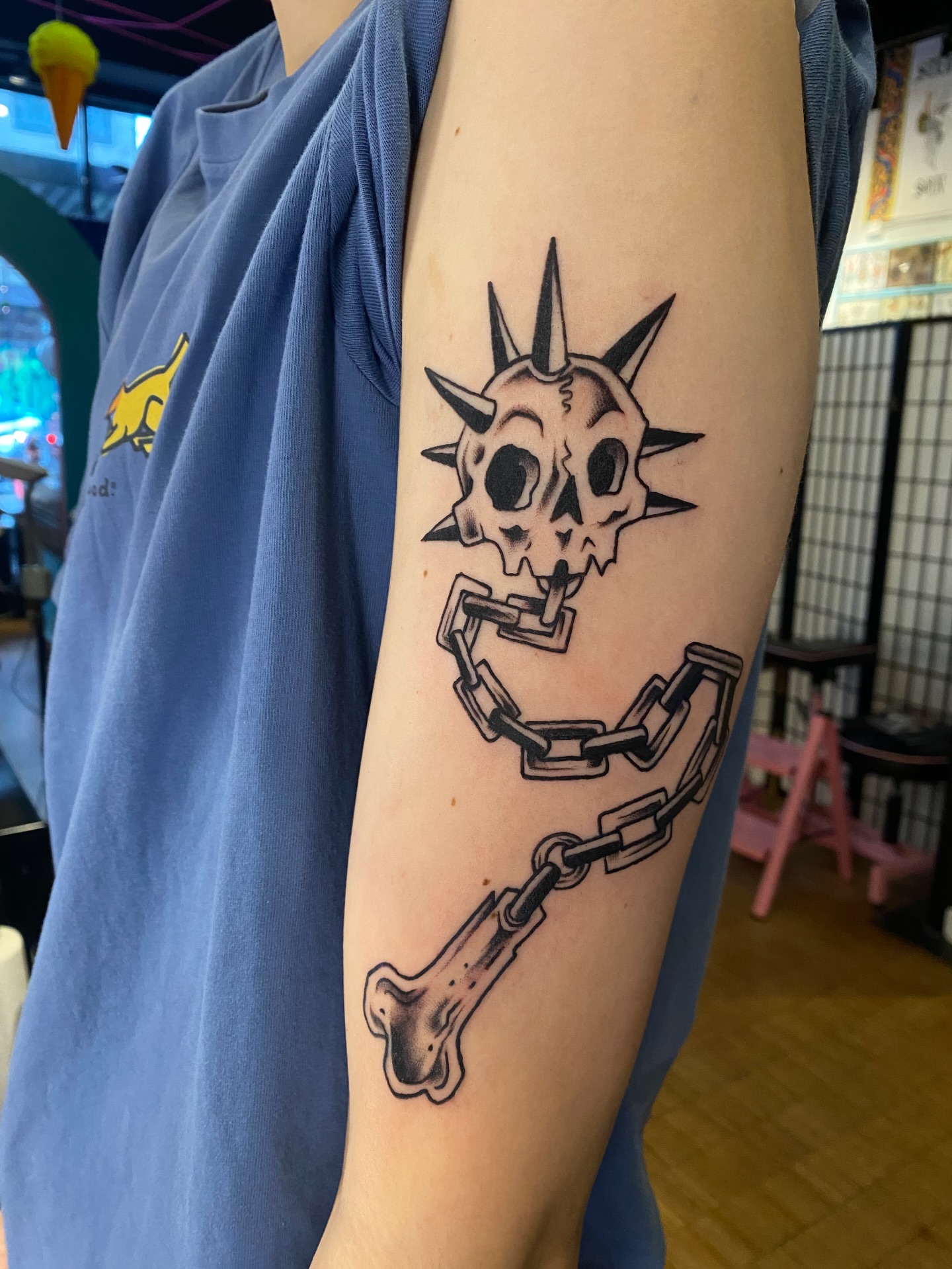 Skull with spikes and chains black and grey tattoo on the forearm by Karl Hegwein, Portland, Oregon