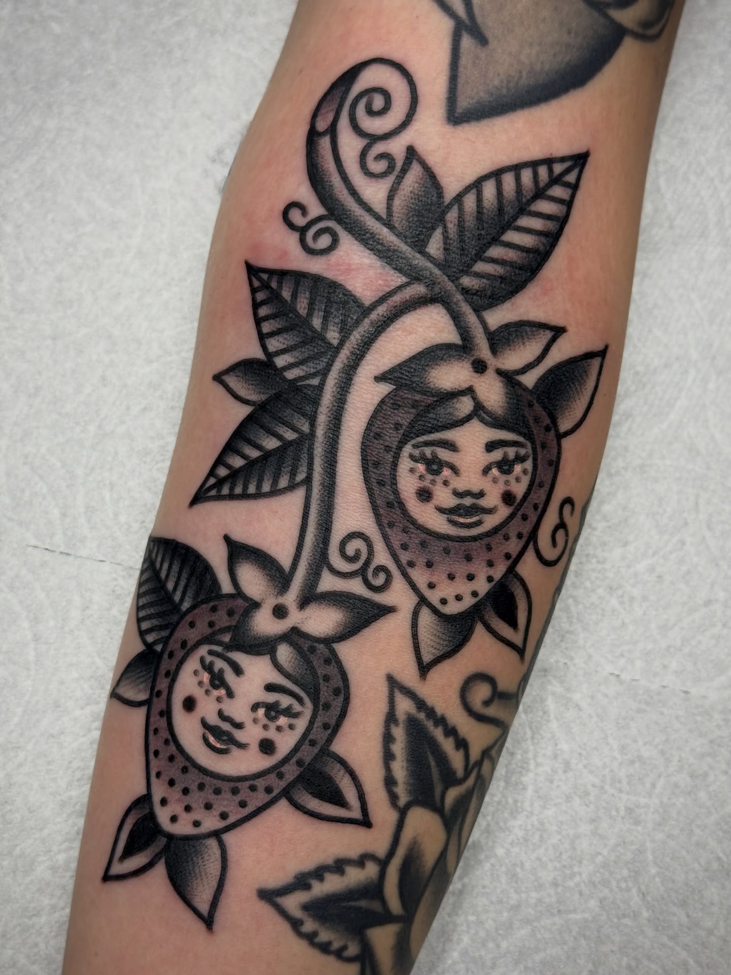 Fruit faces American traditional tattoo on the forearm by Jordan Allen