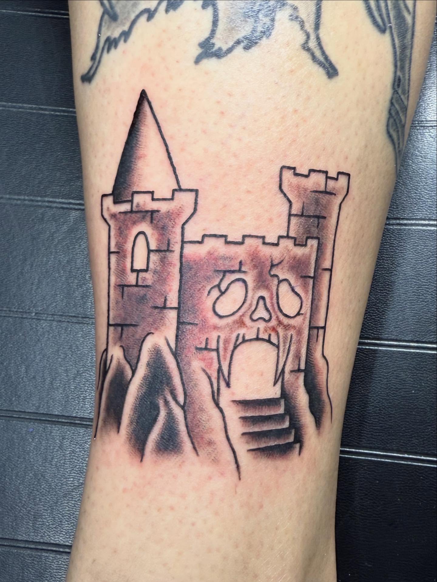 Castle with skull black and grey tattoo on the forearm by Hunter Beyer