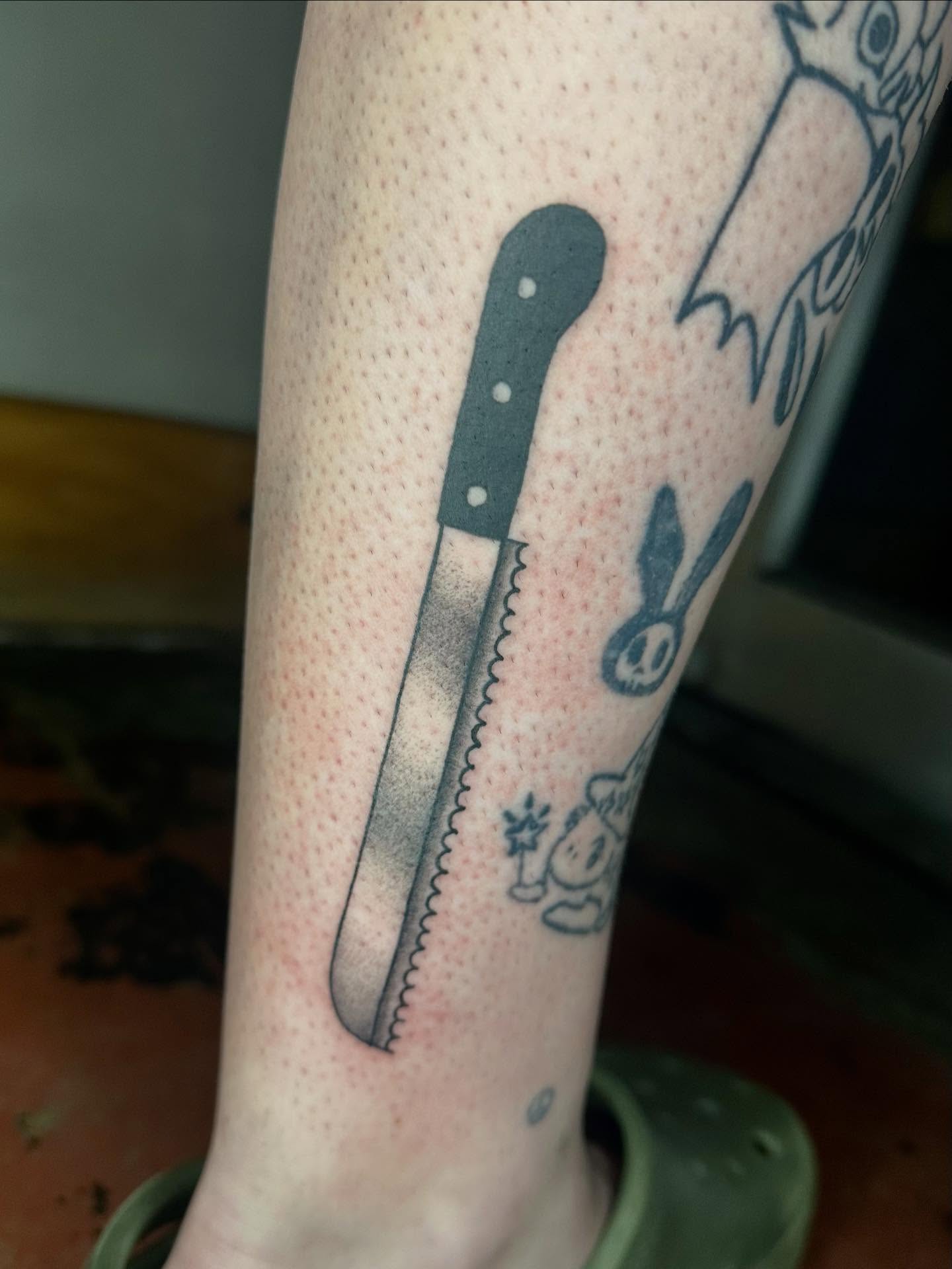 Bread knife black and grey tattoo on the forearm by Jadelin, San Francisco, California