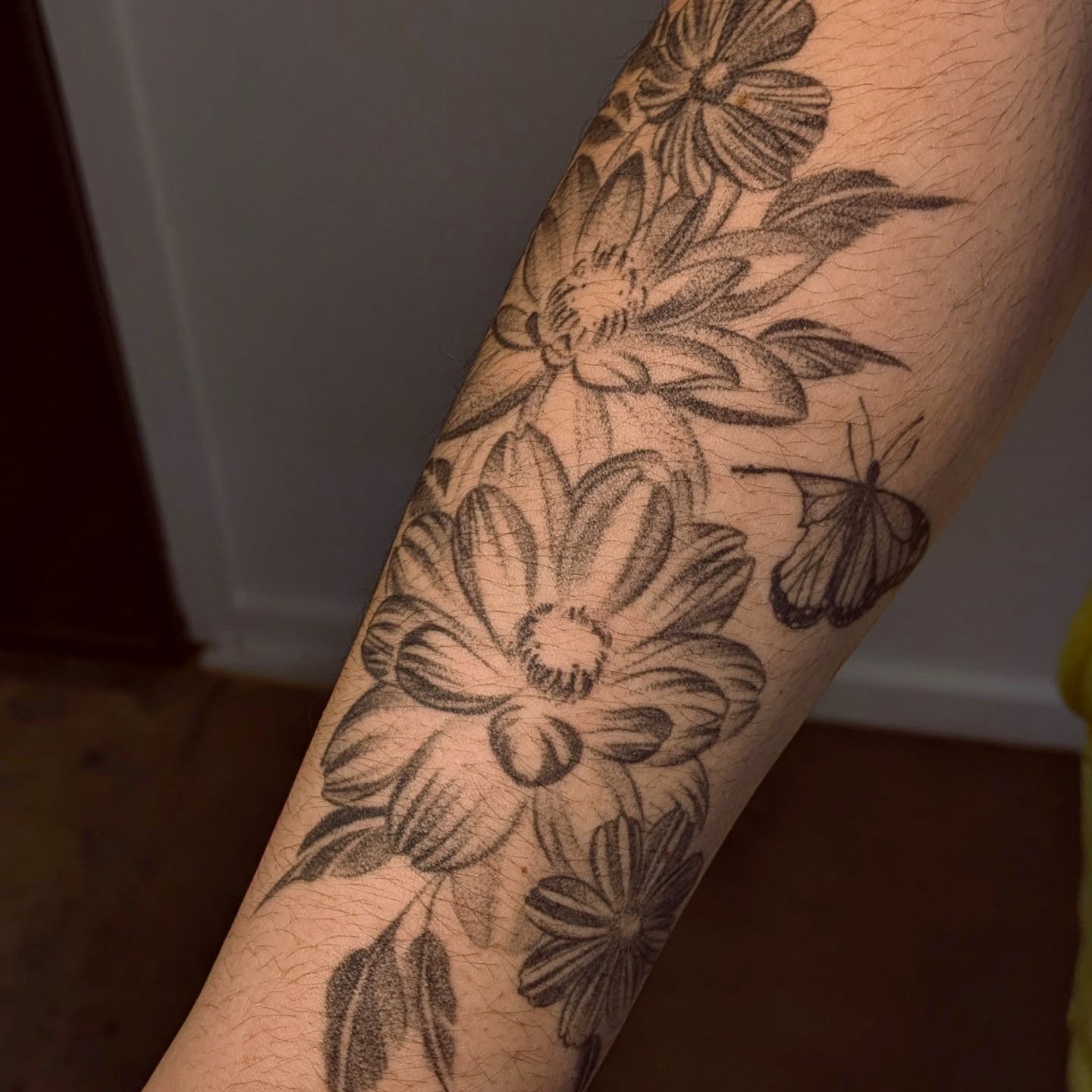 Flowers and moth black and grey tattoo on the forearm by Jasmine Dillon