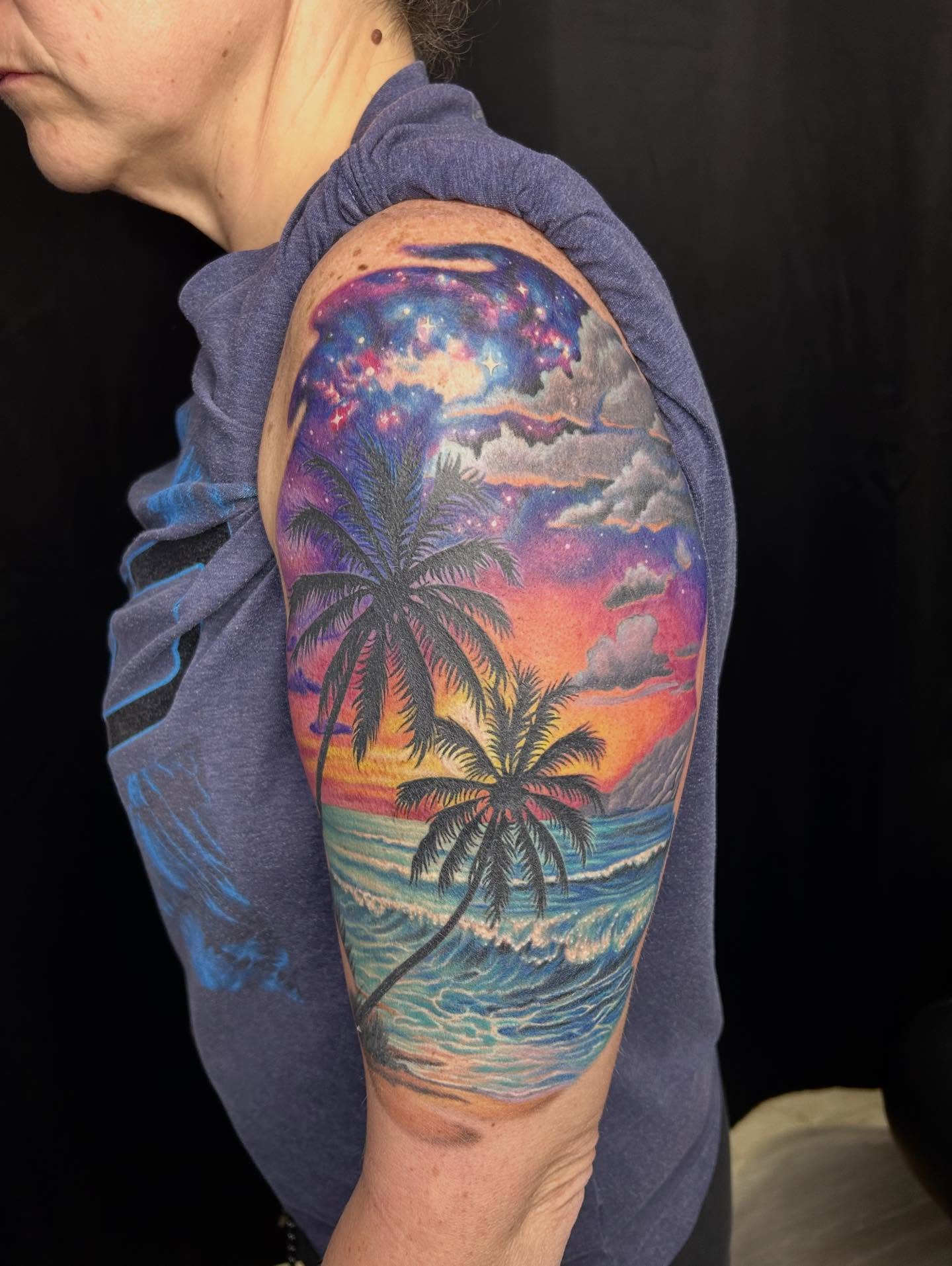 Sunset over ocean realism tattoo on the upper arm by Mary Rose Heckle
