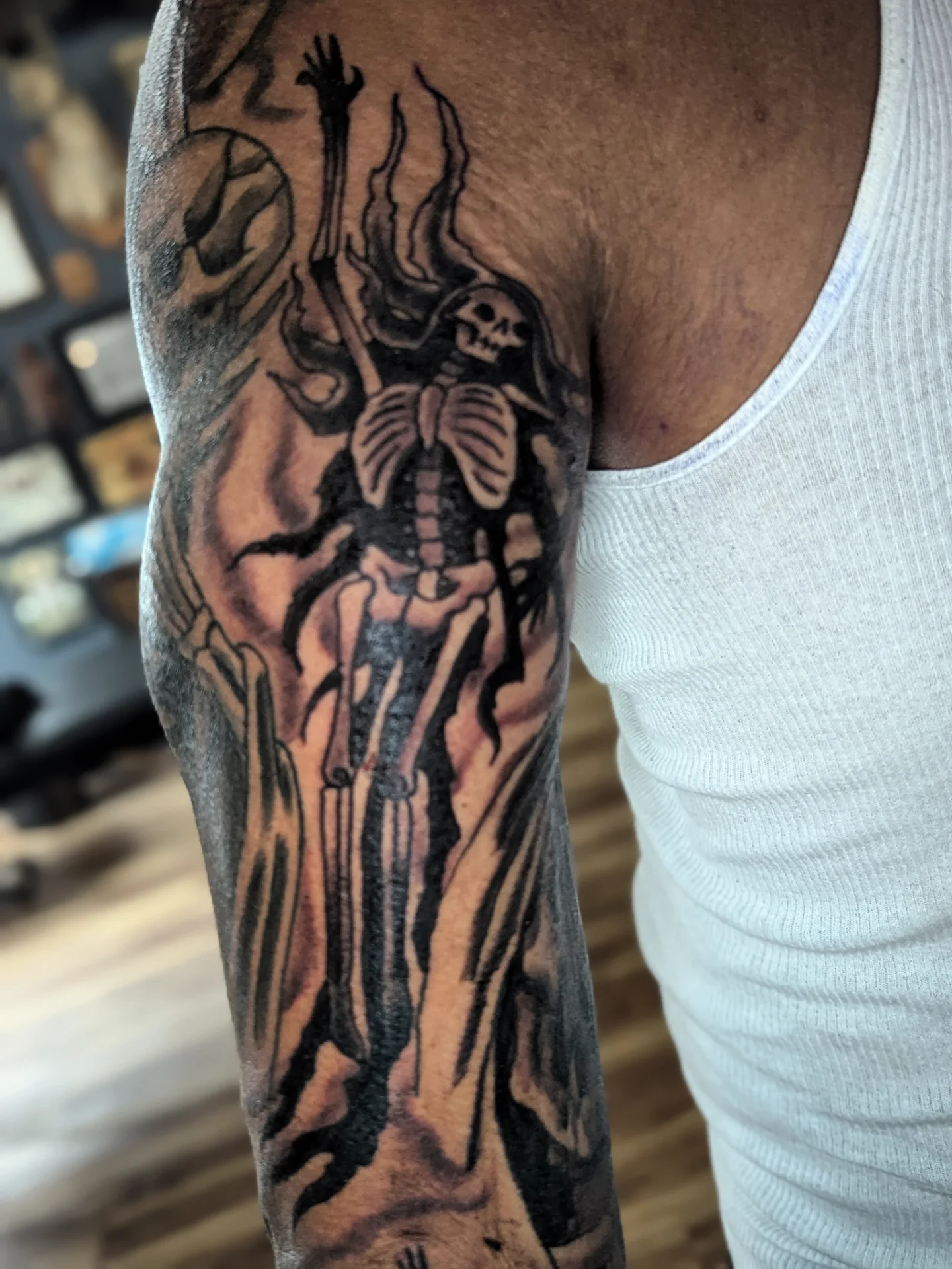 Skeleton with scythe black and grey tattoo on the forearm by Eric Ward