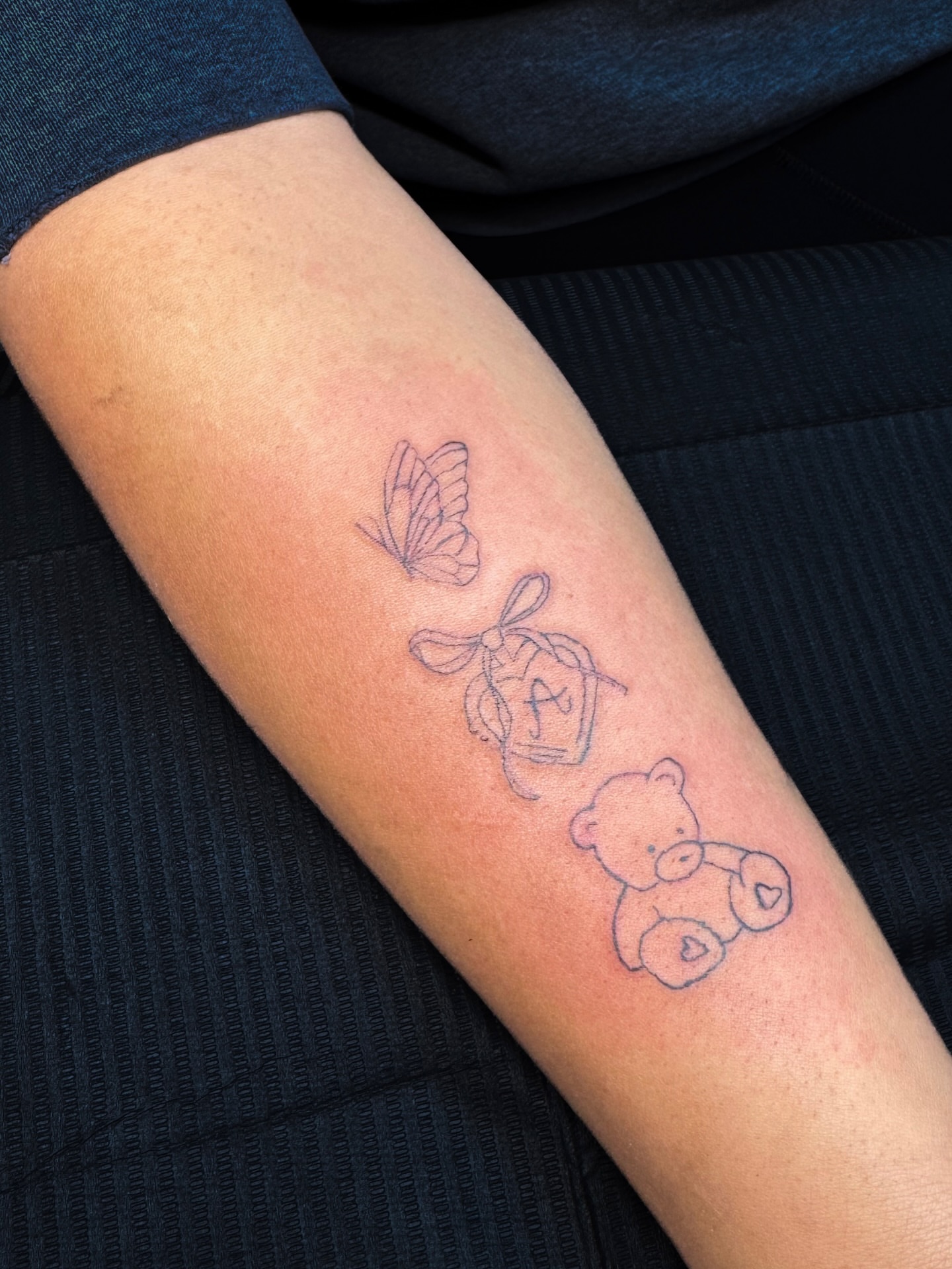 Butterfly, teddy bear, box dotwork tattoo on the forearm by Nicole
