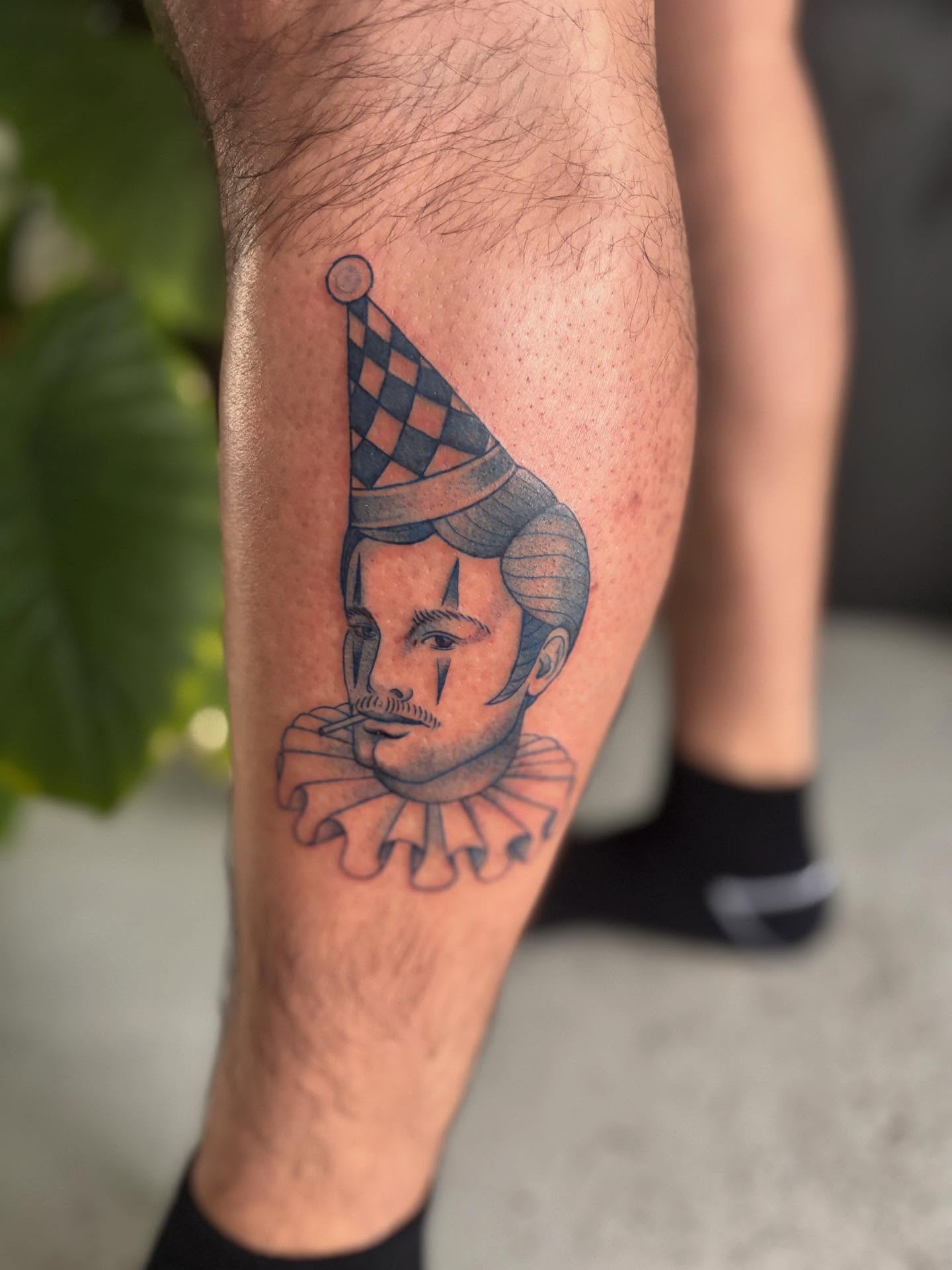 Clown black and grey tattoo on the calf by Marissa Whitaker