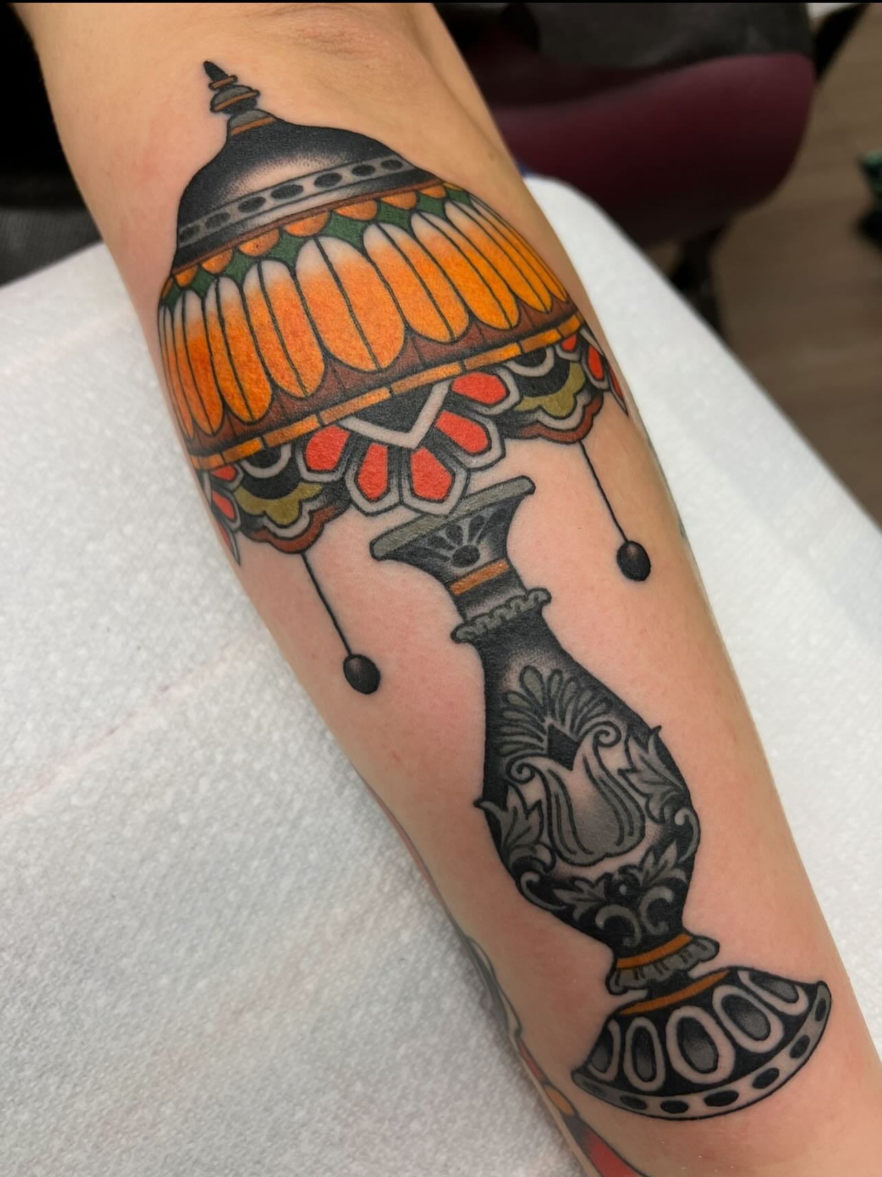 Lamp American traditional tattoo on the forearm by Kelsey Lane