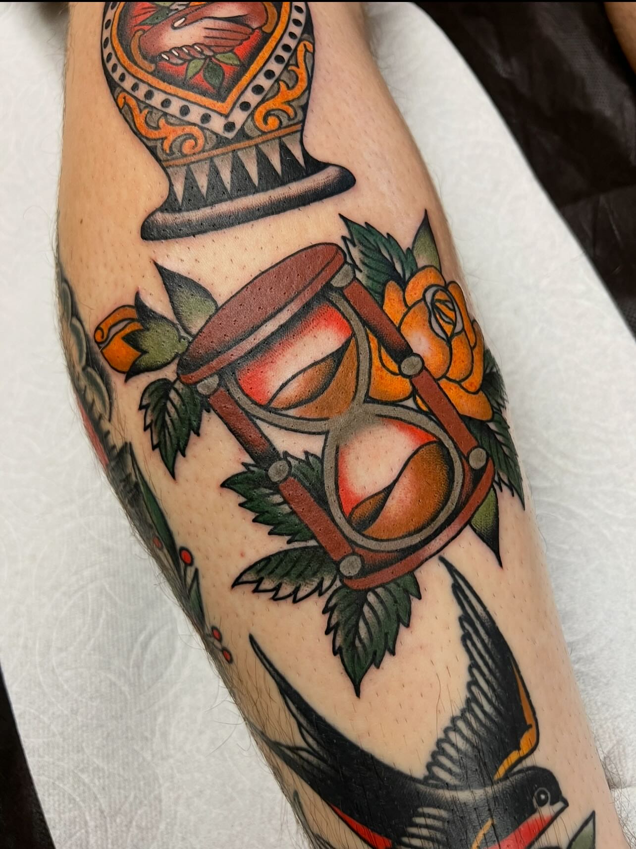 Hourglass and roses American traditional tattoo on the forearm by Kelsey Lane