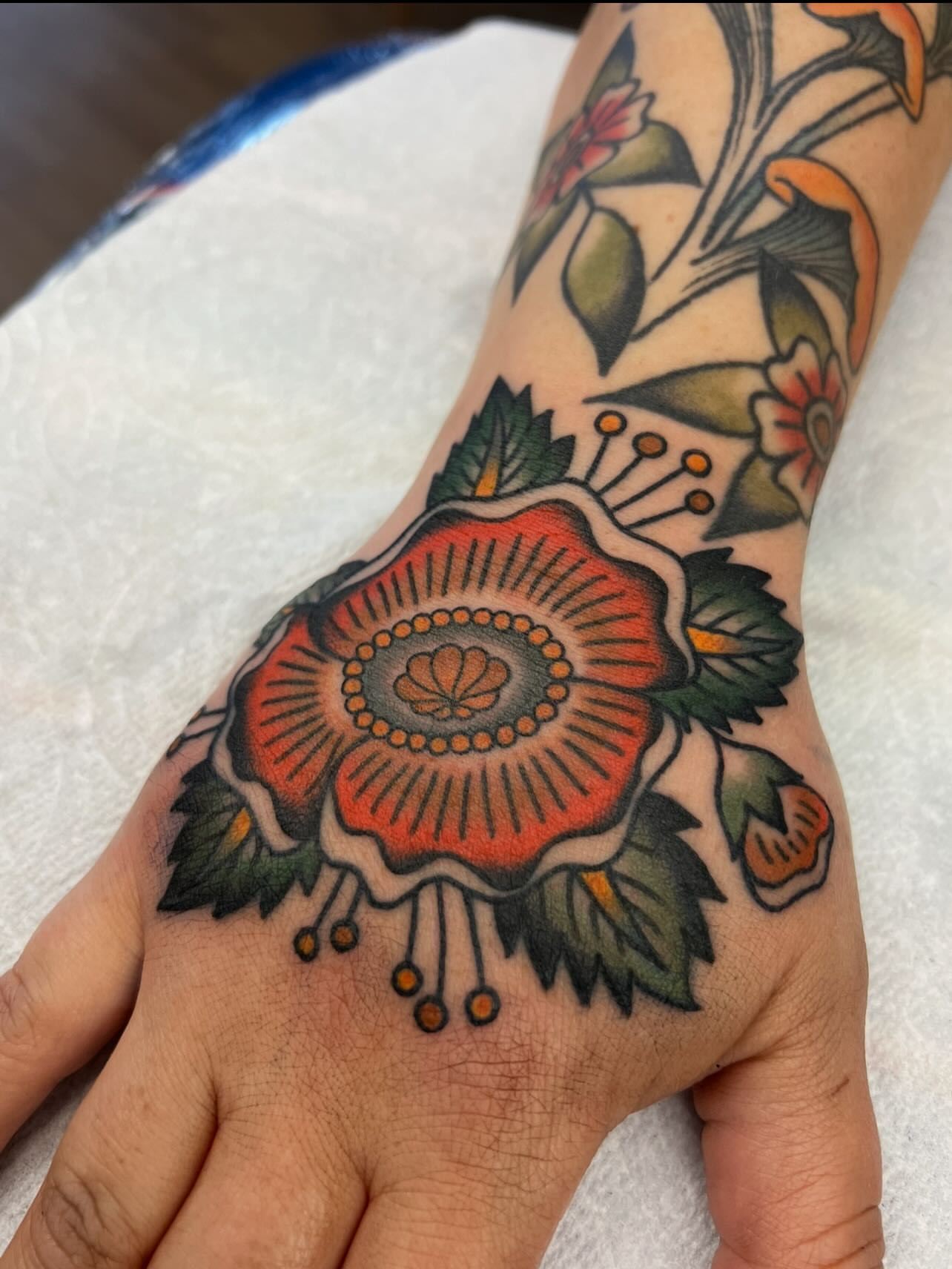 Floral arrangement American traditional tattoo on the hand by Kelsey Lane