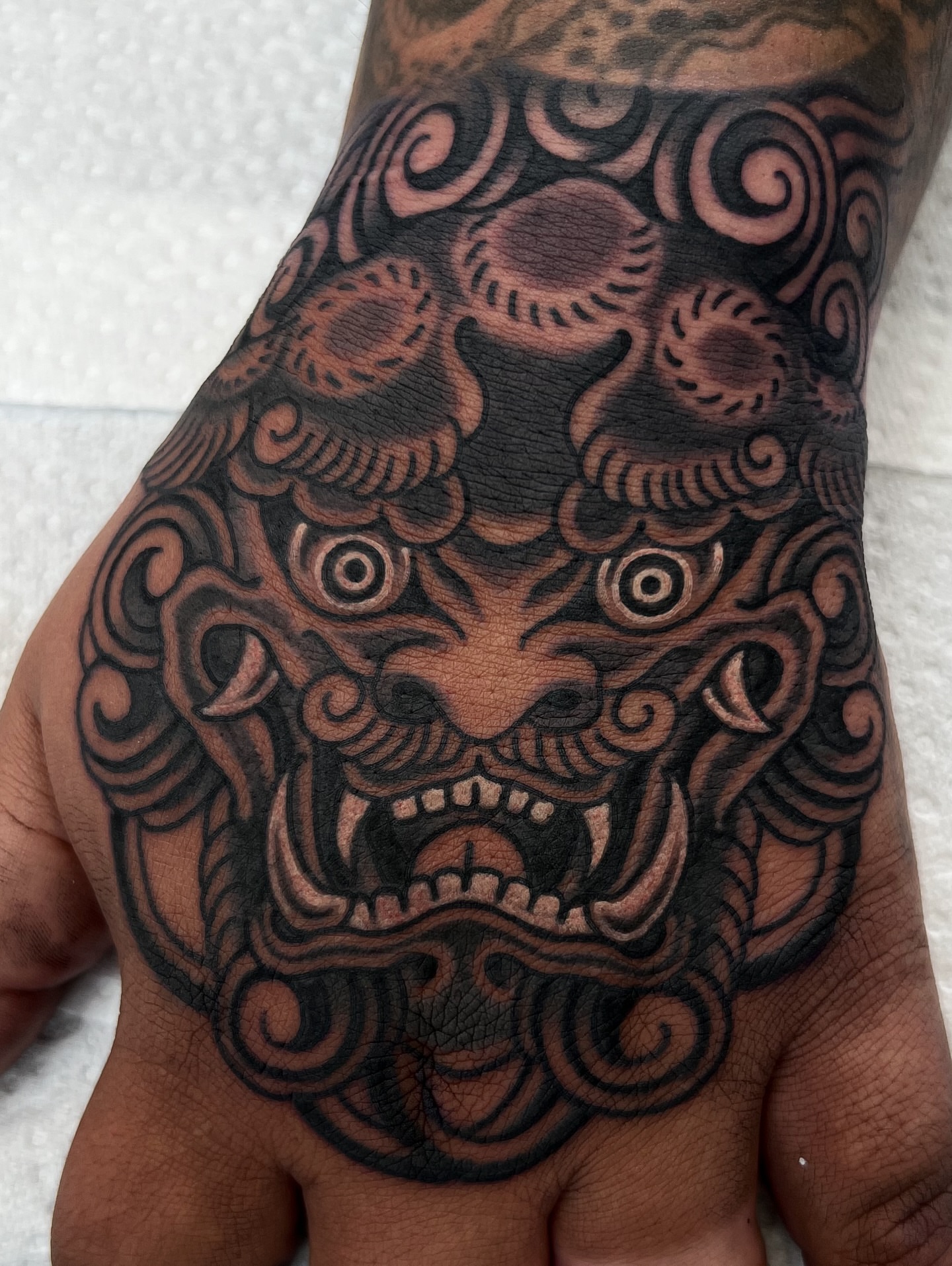 Lion mask japanese irezumi tattoo on the hand by Nick Bridwell, Downey, California