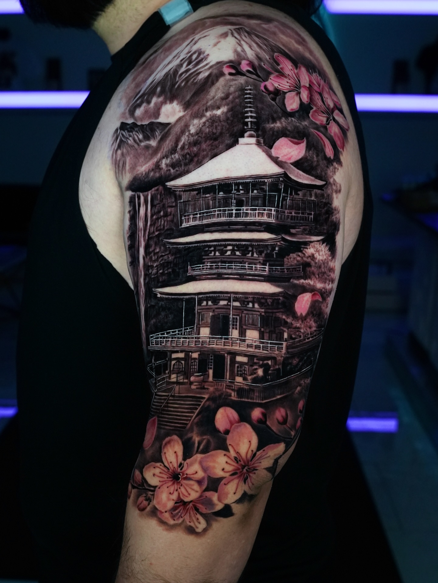 Cherry blossoms and pagoda japanese irezumi tattoo on the upper arm by Lynn Hoang, Honolulu, Hawaii