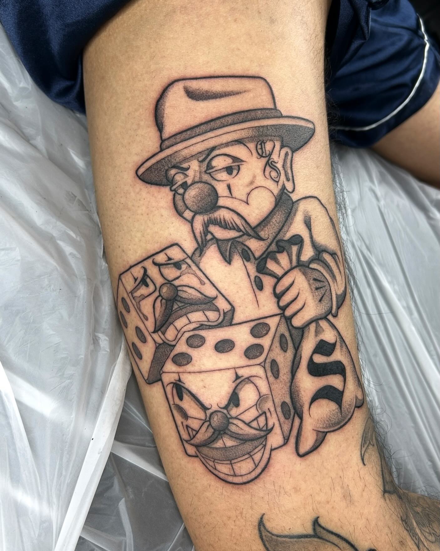 Clown with dice black and grey tattoo on the forearm by Joon 치카노레터링