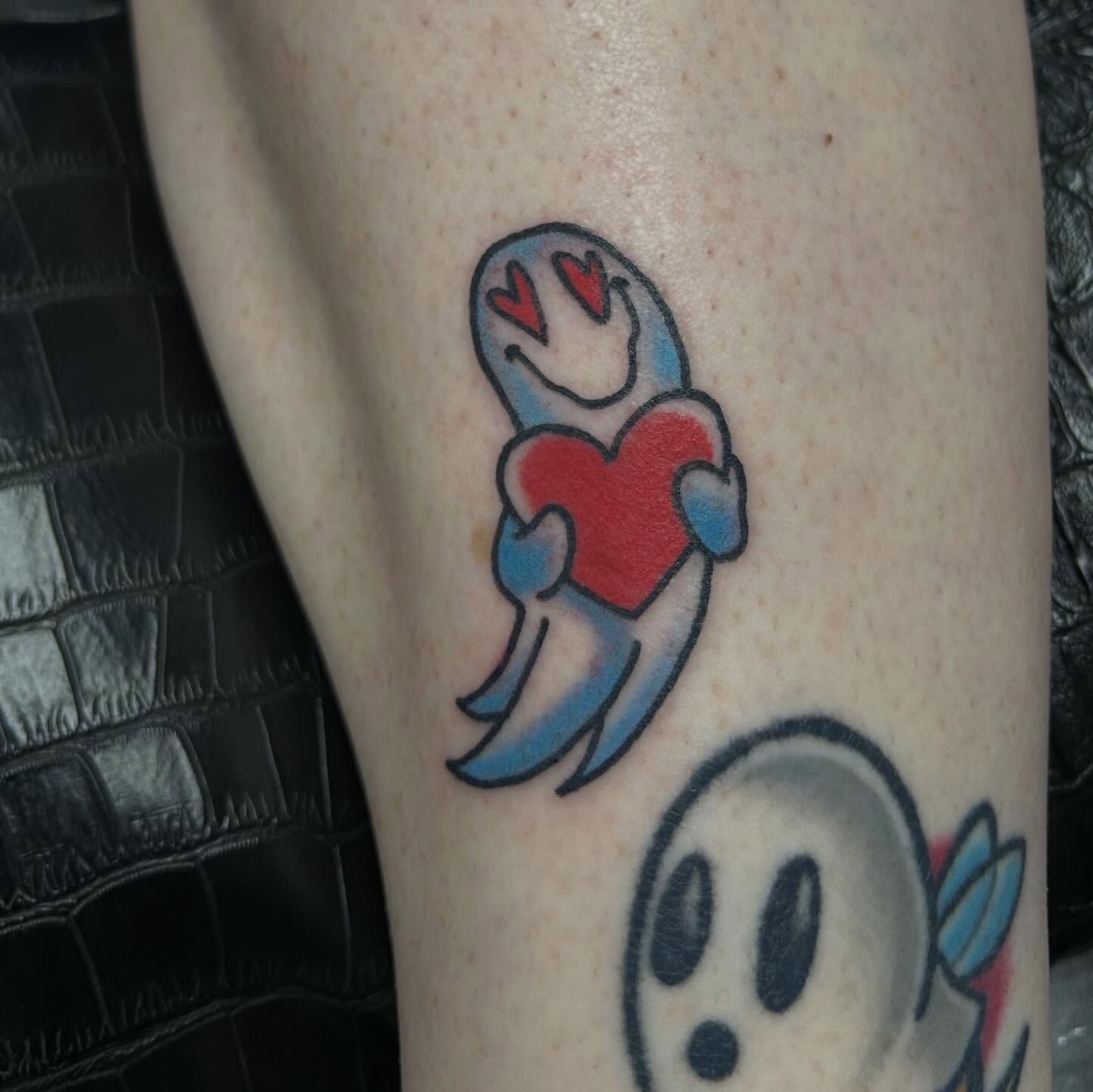 Ghost holding heart new school tattoo on the forearm by 𝕸𝖞𝖆