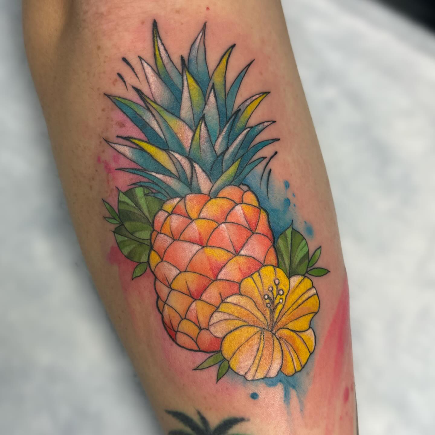 Pineapple and flower watercolor tattoo on the forearm by Elly Bordwell