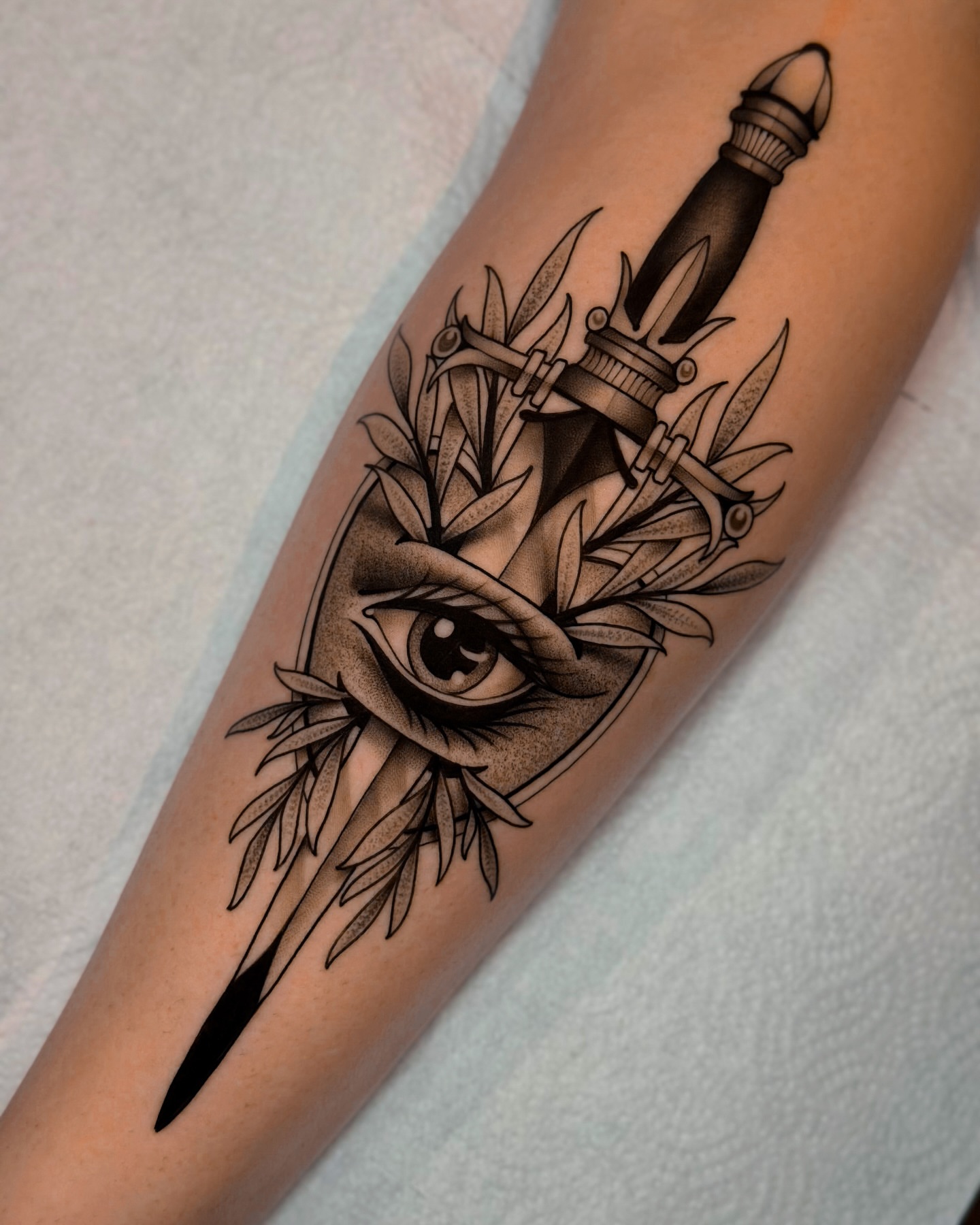 Eye and dagger realism tattoo on the forearm by San Diego