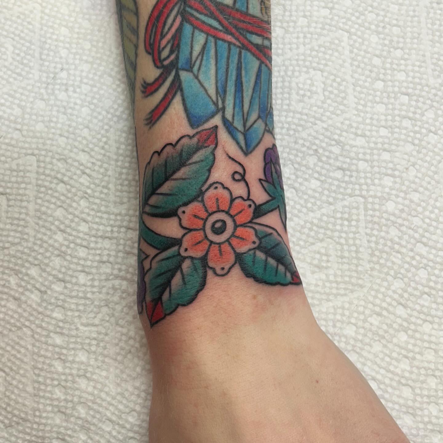Flower and crystal American traditional tattoo on the forearm by Kelsey Lyons