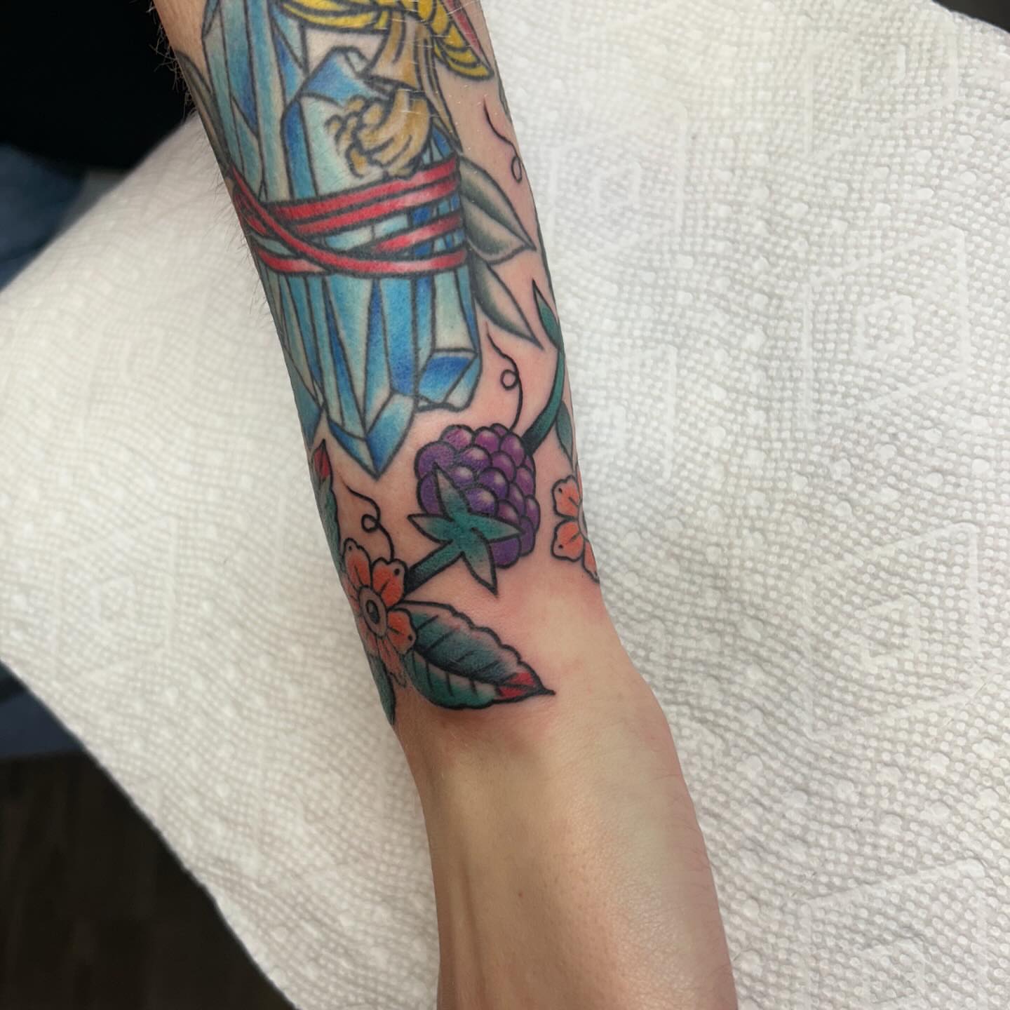 Crystal and floral American traditional tattoo on the forearm by Kelsey Lyons