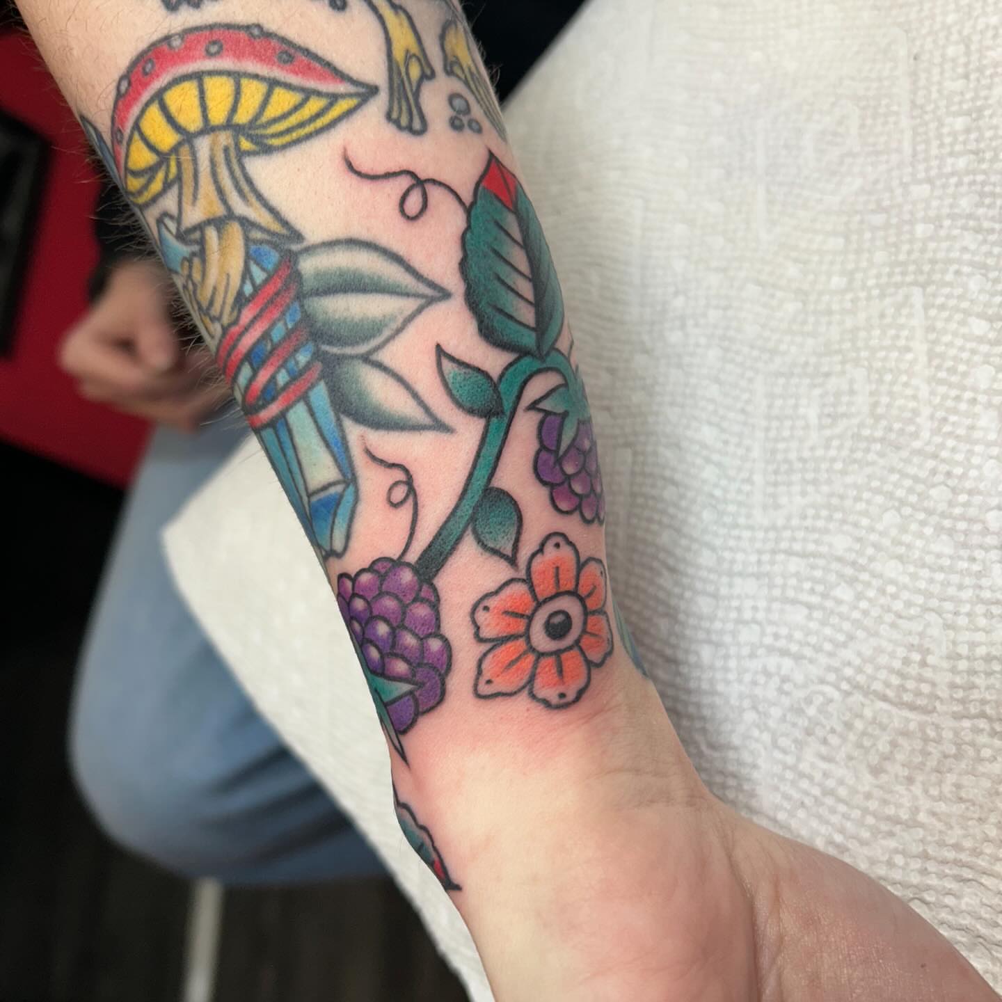 Mushroom and floral American traditional tattoo on the forearm by Kelsey Lyons