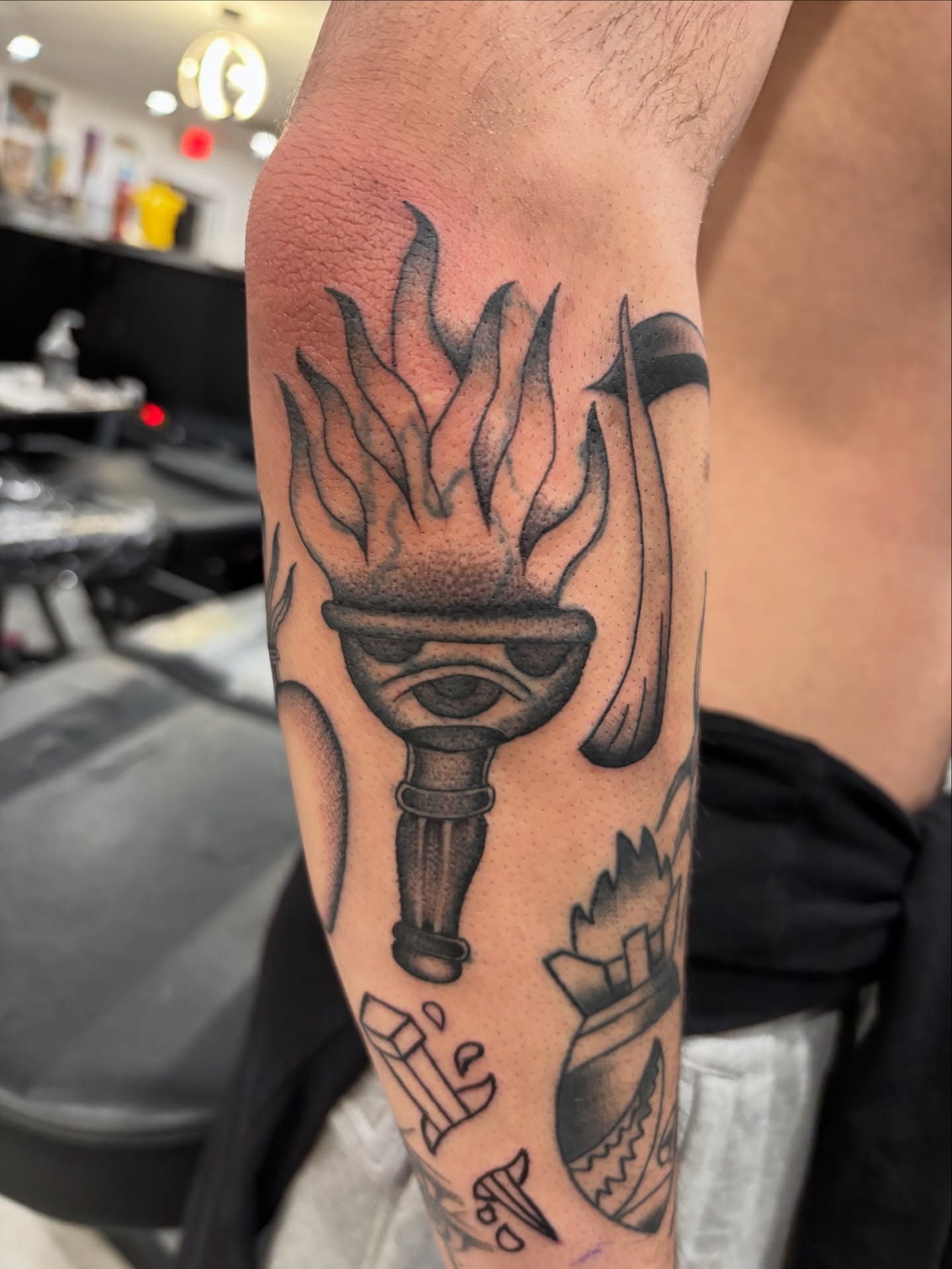 Torch with flames black and grey tattoo on the forearm by Miklo Montoya