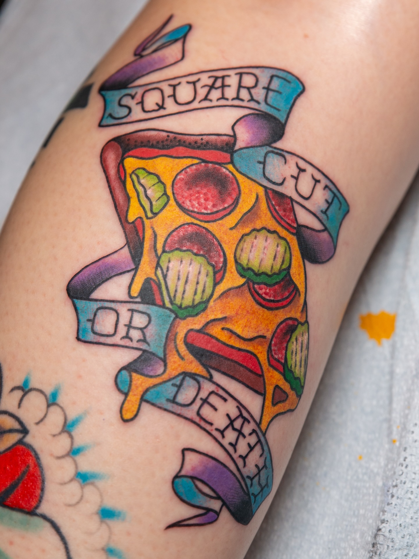 Pizza slice American traditional tattoo on the forearm by Trevor Aarsvold, Minneapolis, Minnesota