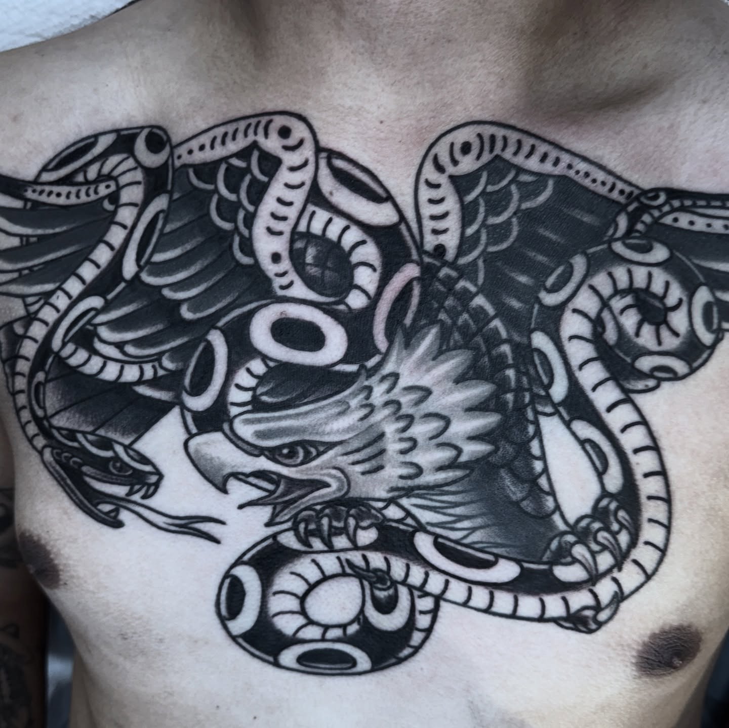 Dragon and snake American traditional tattoo on the chest by Lisa Del Toro