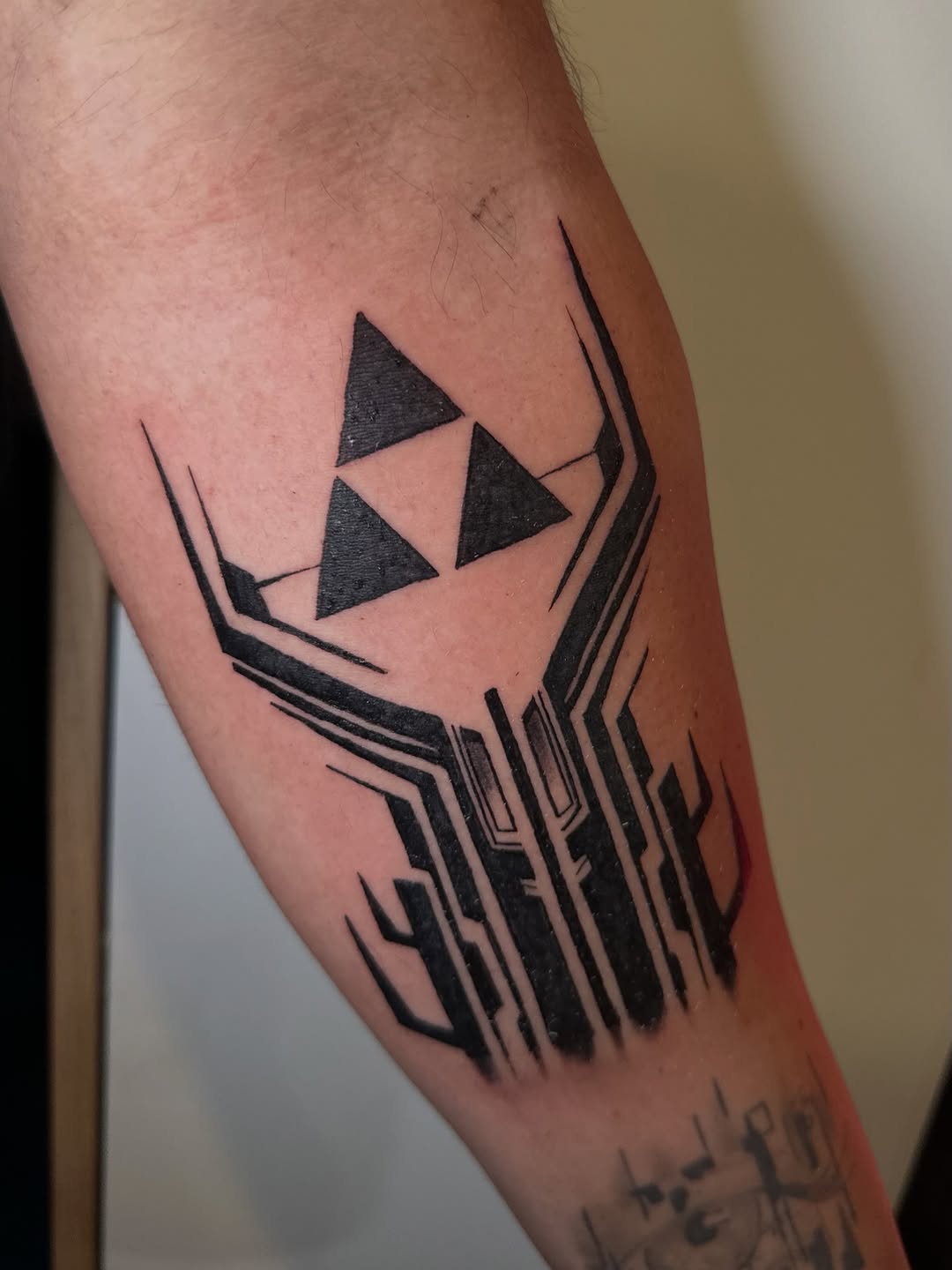 Triforce symbol with abstract design geometric tattoo on the forearm by Alexander Haber