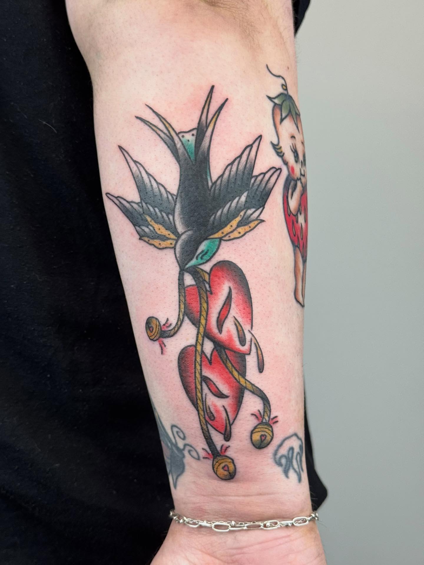 Bird and heart American traditional tattoo on the forearm by π©πͺπ¬