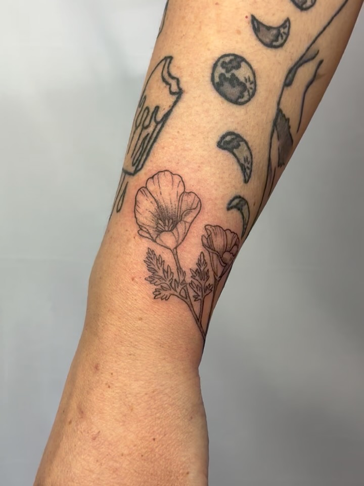 Flowers and celestial symbols black and grey tattoo on the forearm by ⊹ Avery Peterson ⊹