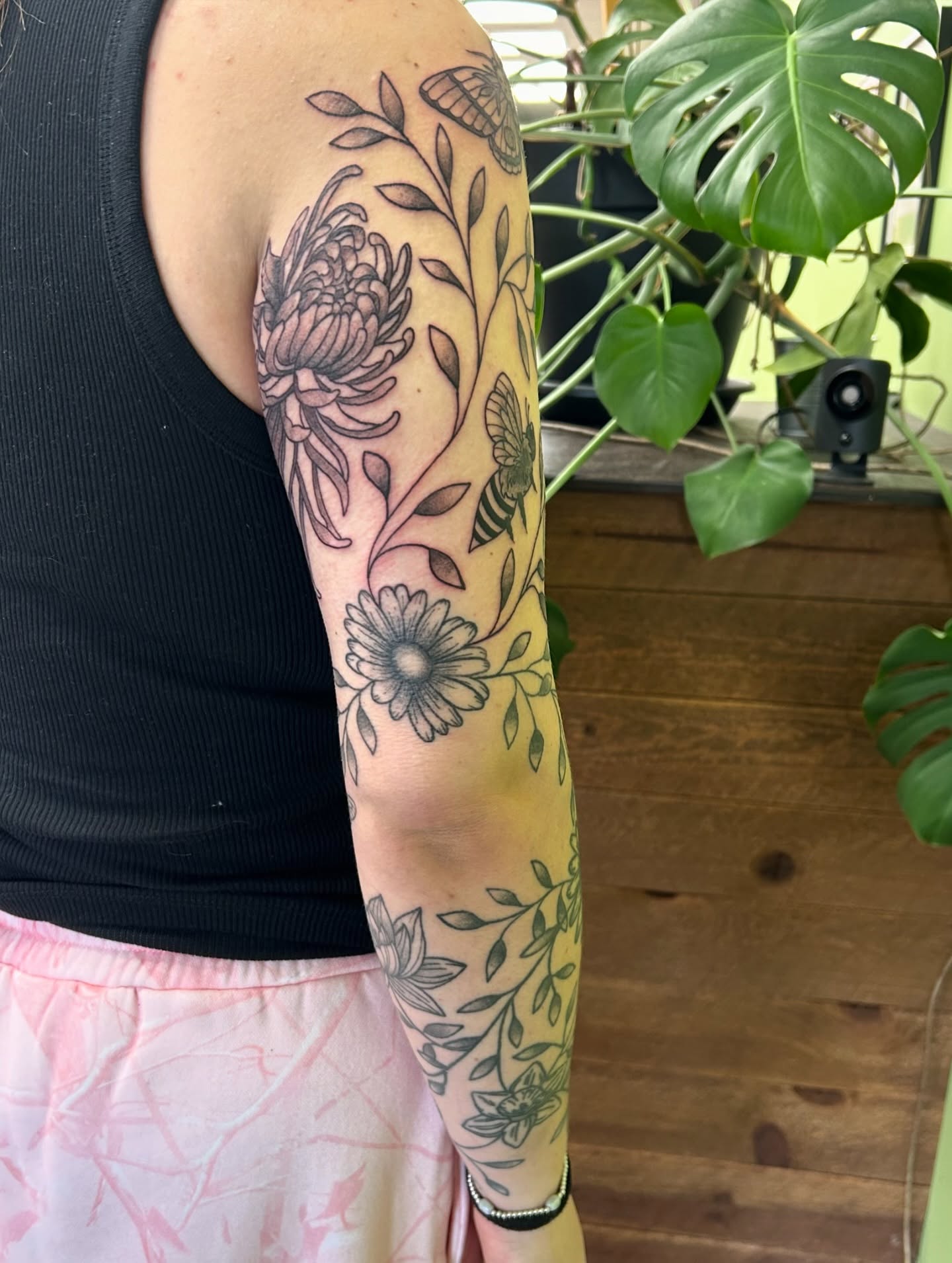 Floral and bee neo-traditional tattoo on the forearm by Courtney