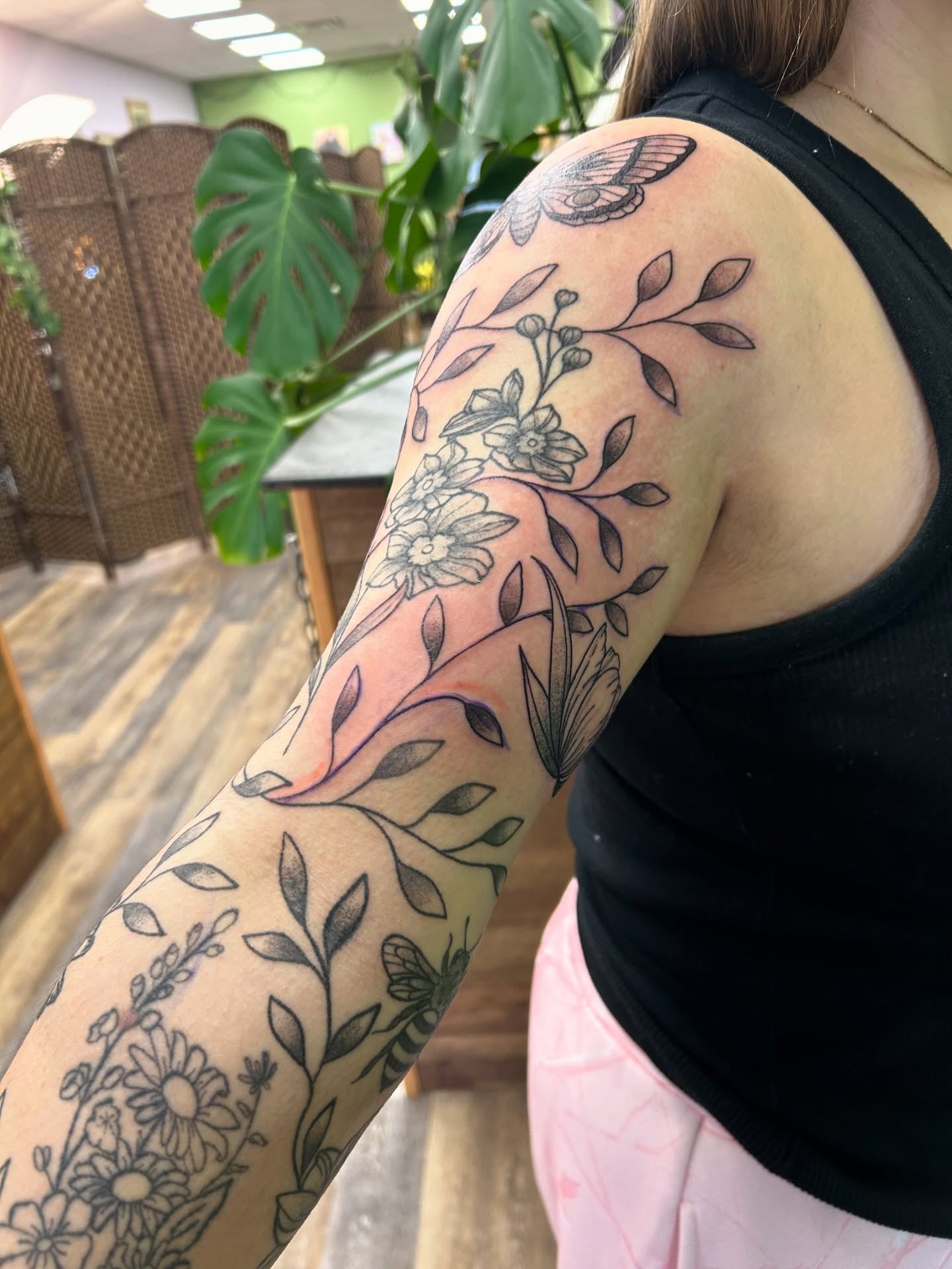 Floral vine black and grey tattoo on the upper arm by Courtney