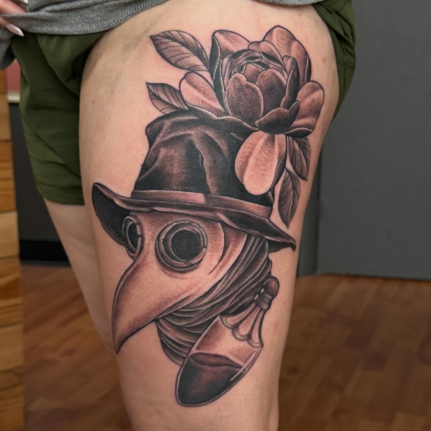 Plague doctor mask with rose realism tattoo on the thigh by Matt Hattaway
