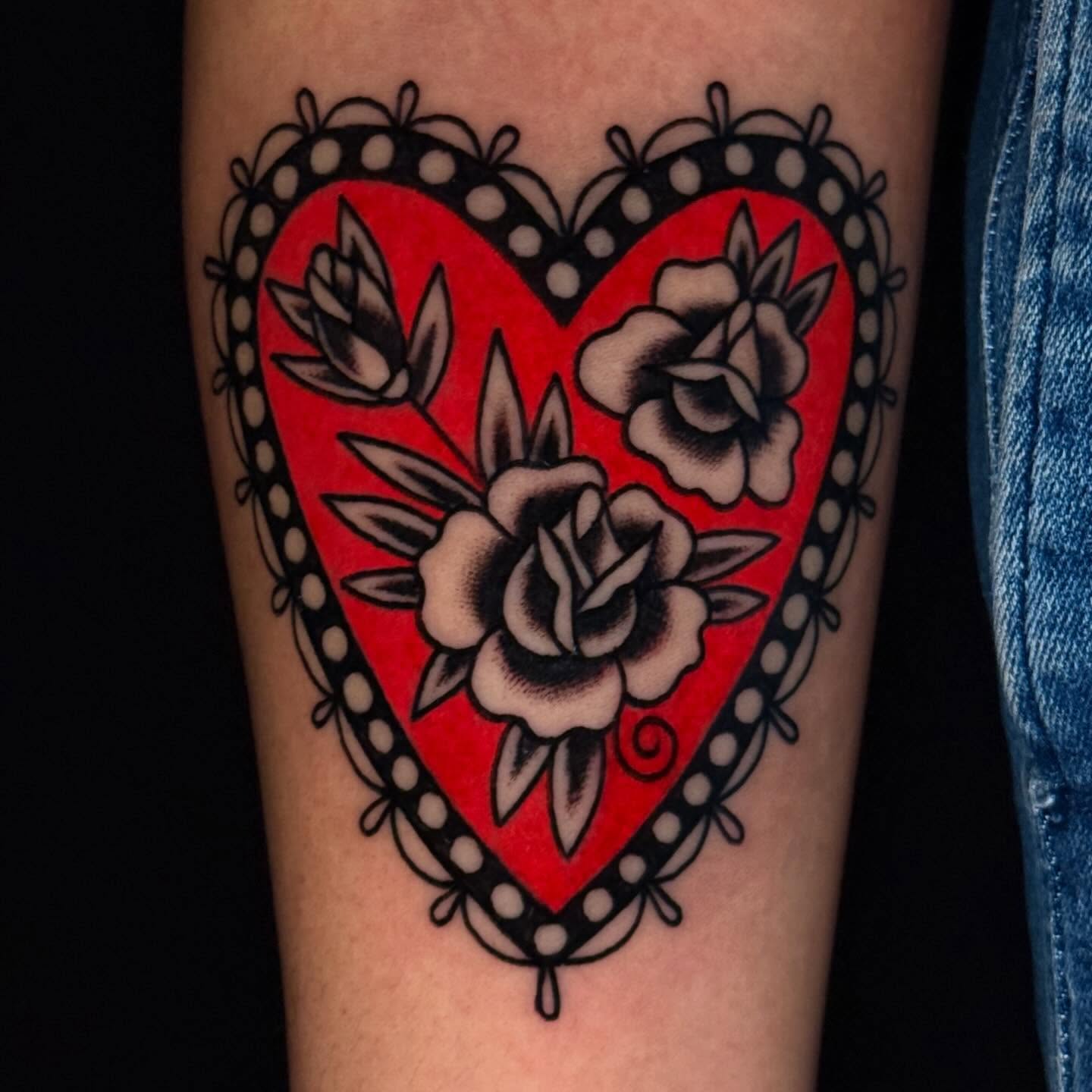 Heart with roses American traditional tattoo on the forearm by Mallory Brown