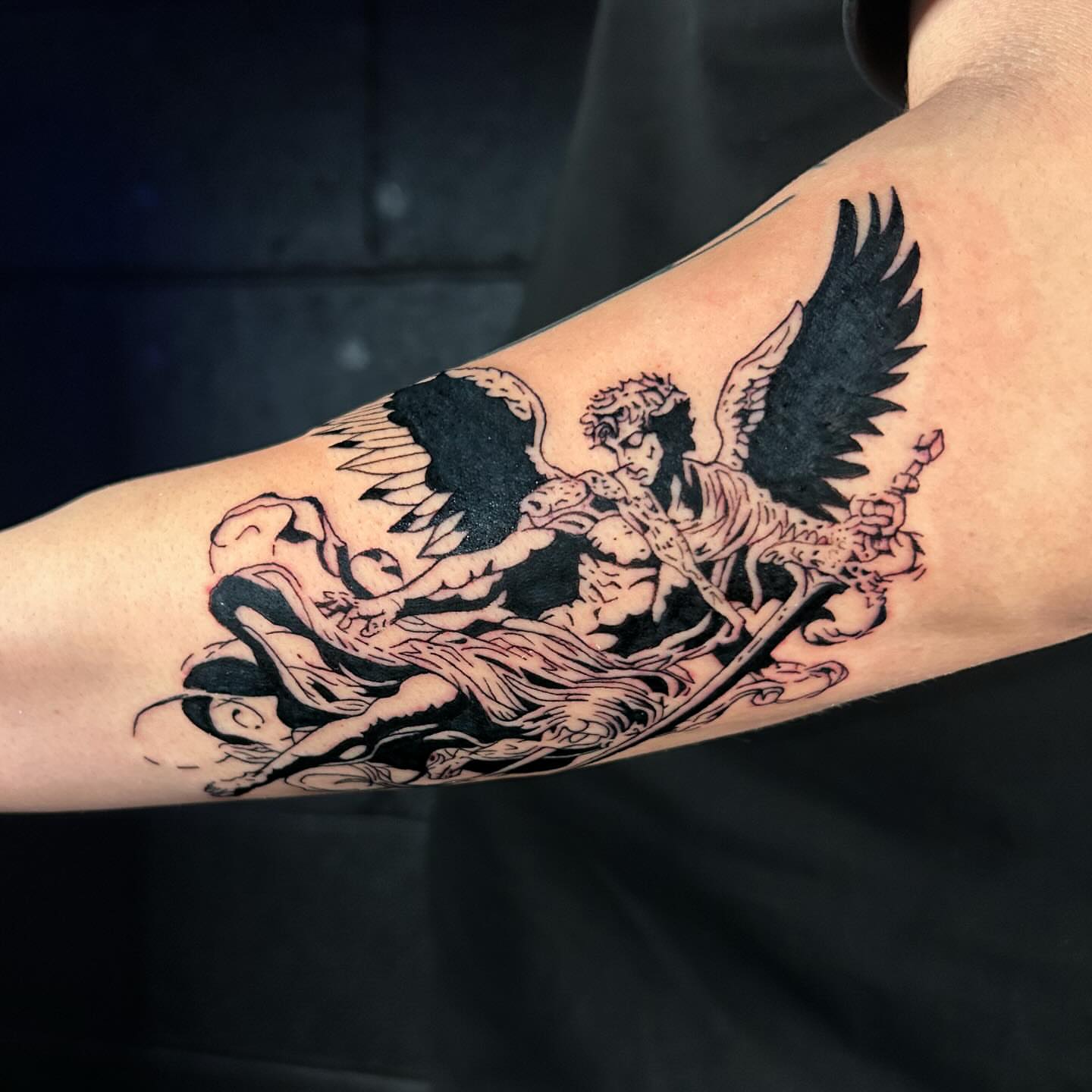 Angel and dragon black and grey tattoo on the forearm by Maia Pizarro