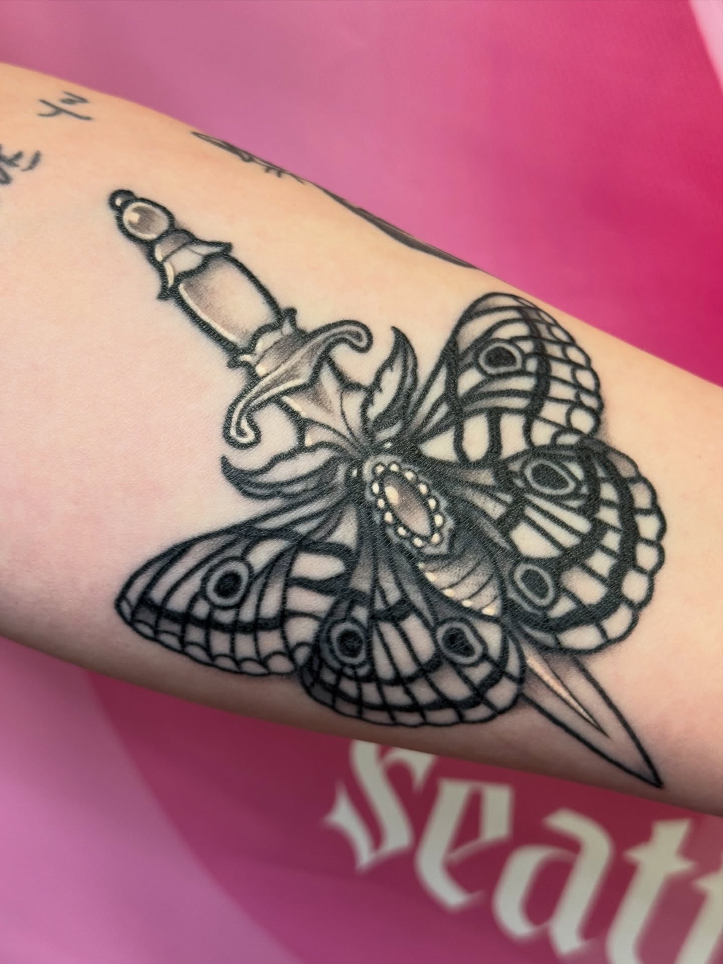 Butterfly and dagger black and grey tattoo on the forearm by Chelsea Graham, Seattle, Washington