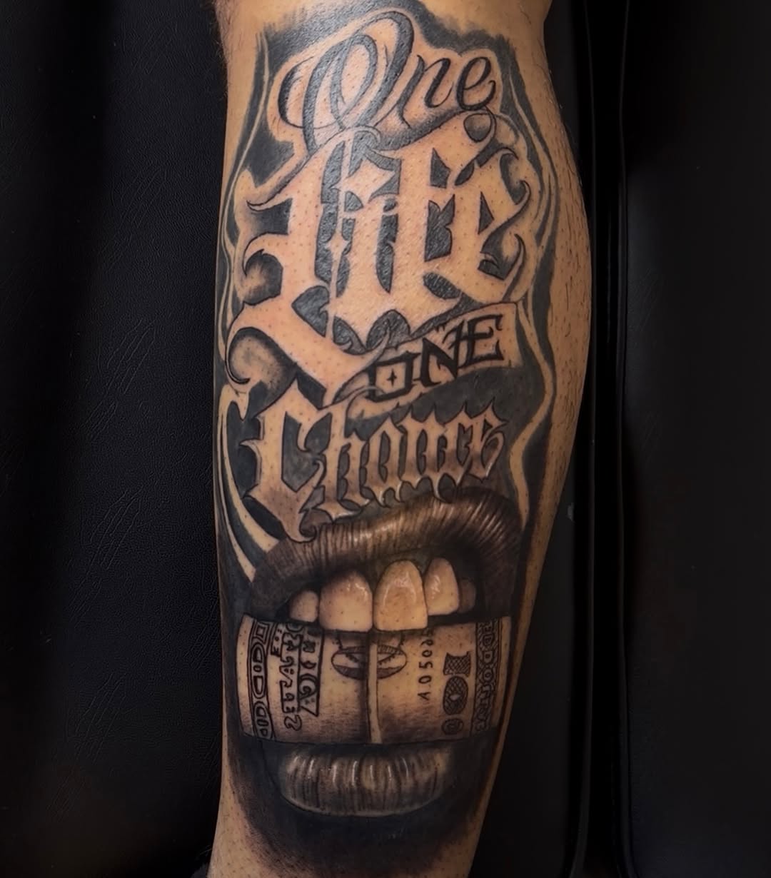 Lips with money and lettering Chicano tattoo on the forearm by 🐺